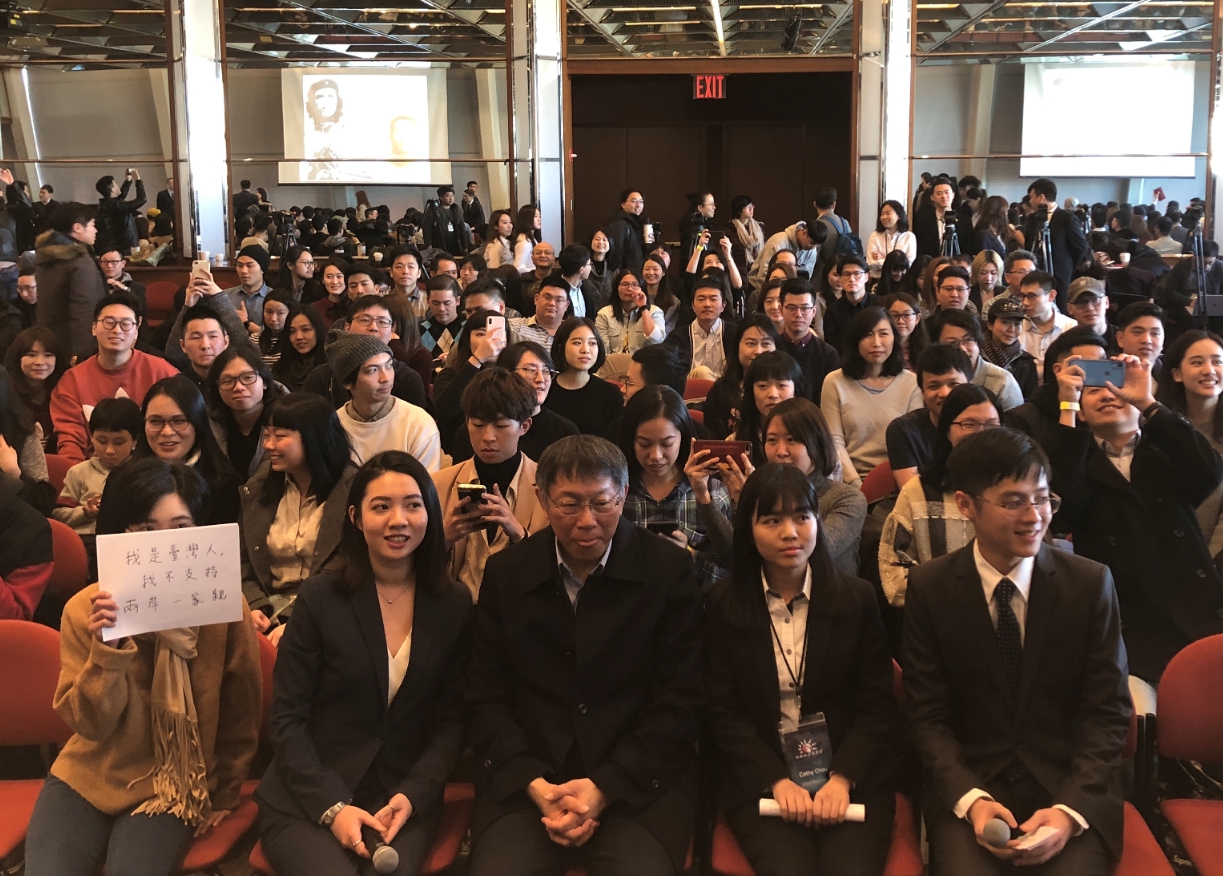有台灣學生與柯文哲大合照時，拿出手寫紙牌抗議「兩岸一家親」。