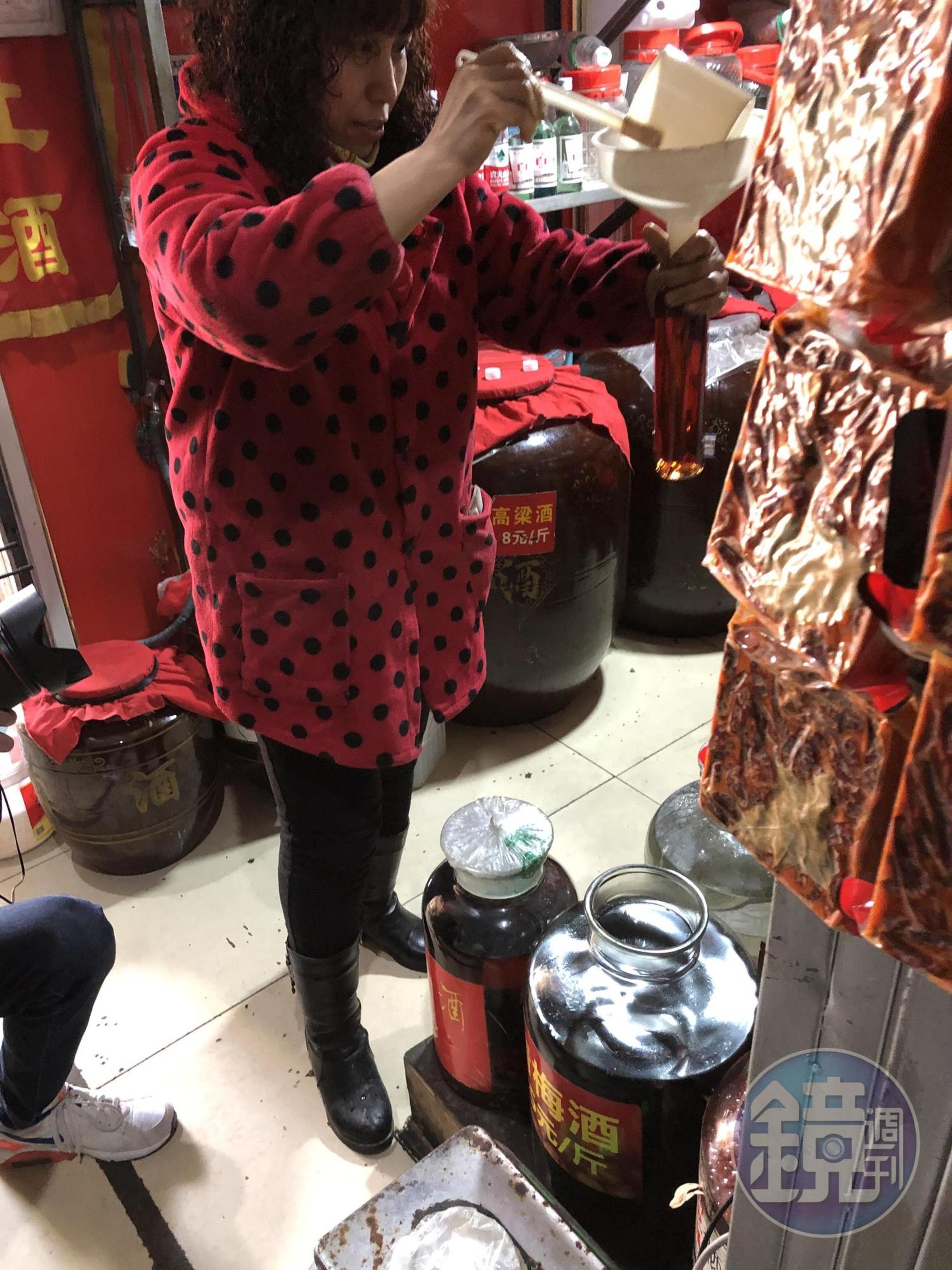 老闆娘是江振誠的老朋友，專心地為他打上兩瓶青梅酒。