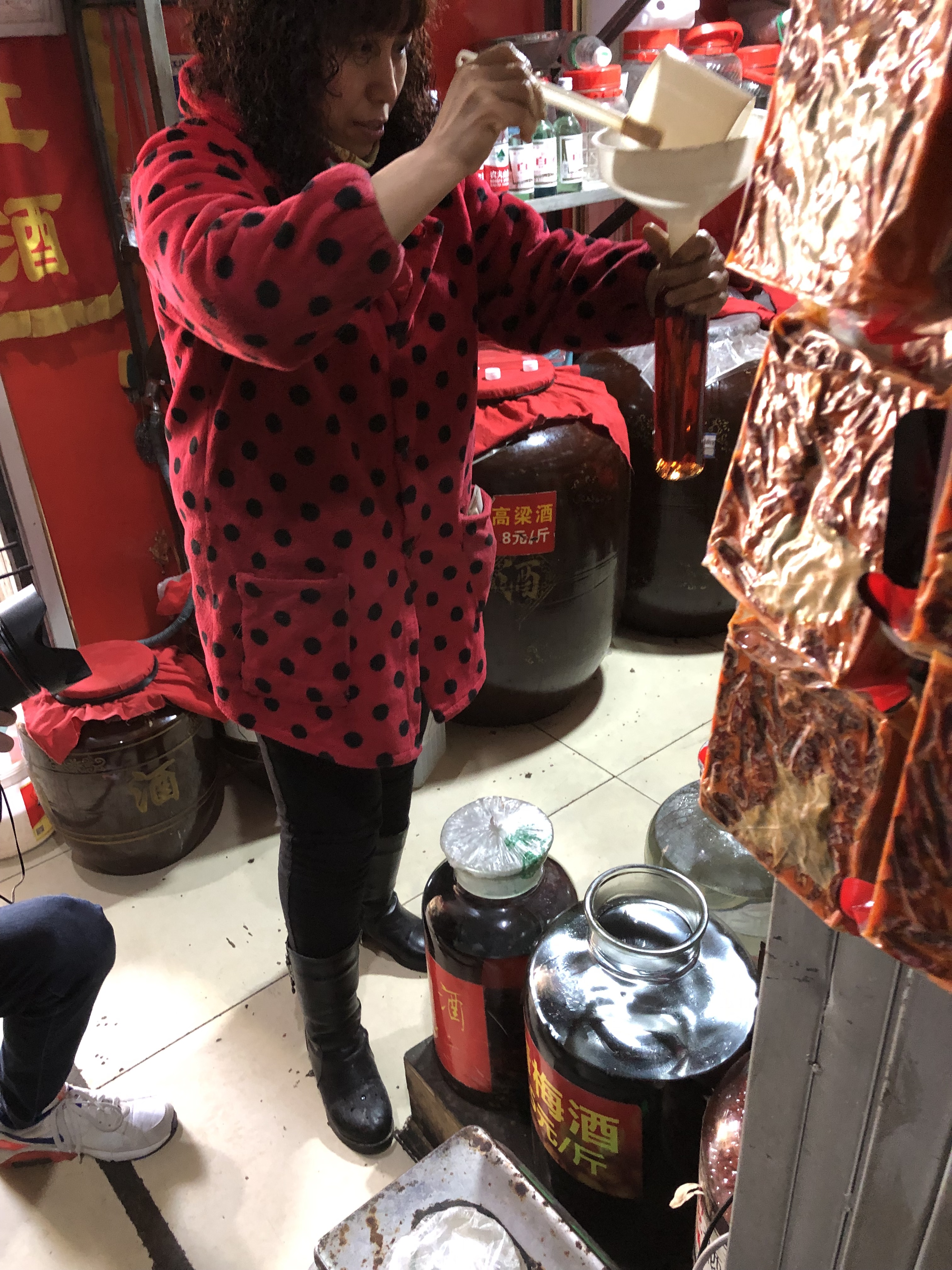 老闆娘是江振誠的老朋友，專心地為他打上兩瓶青梅酒。