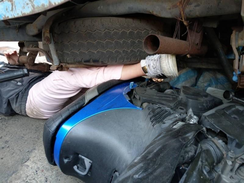 劉女連人帶車滑入路旁小貨車底，疼痛難耐動彈不得。（警方提供）