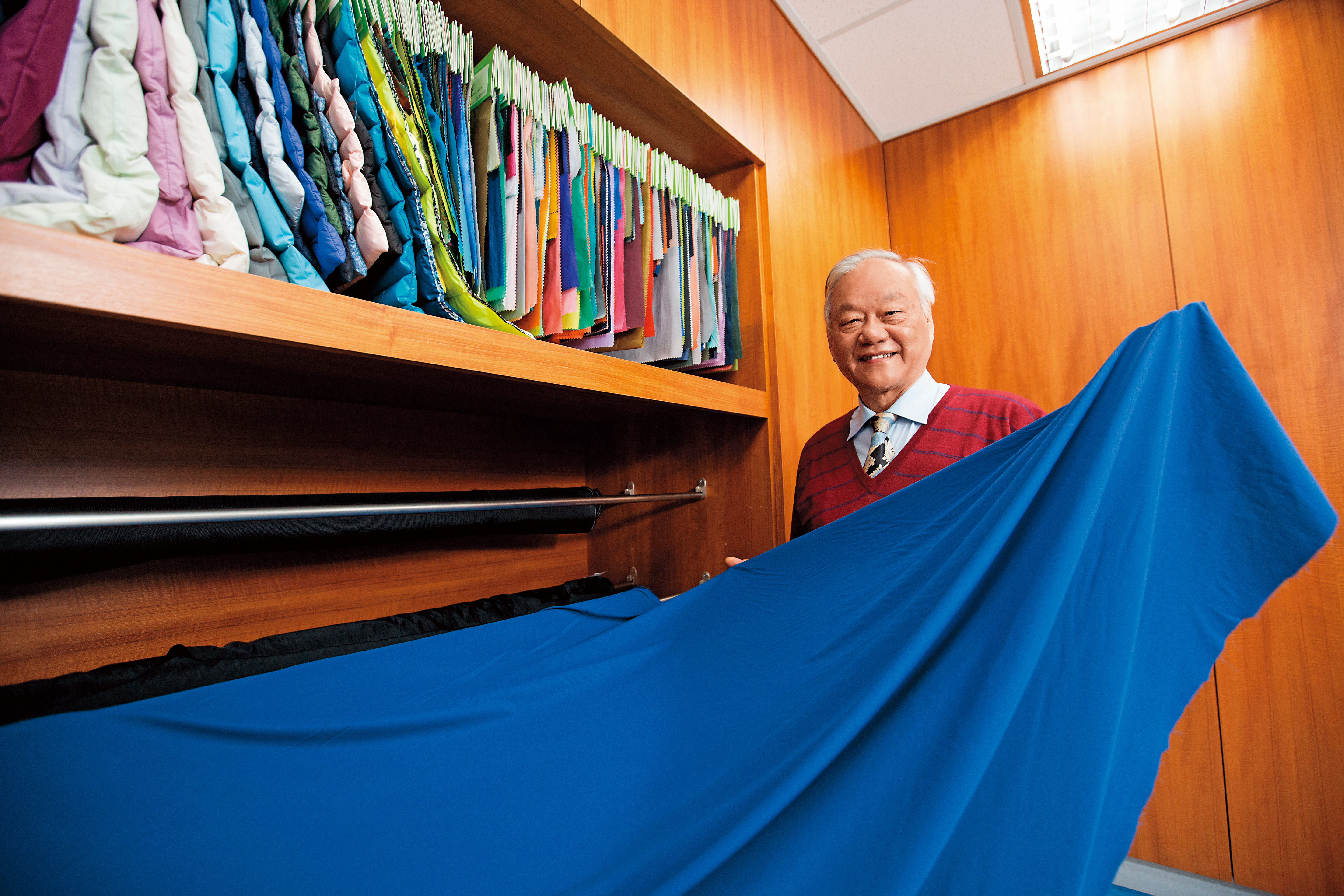 尤利春創立50億元紡織代銷王國，與上游纖維廠共同研發紗線，製作成布料樣品，提供下游紡織廠選擇。