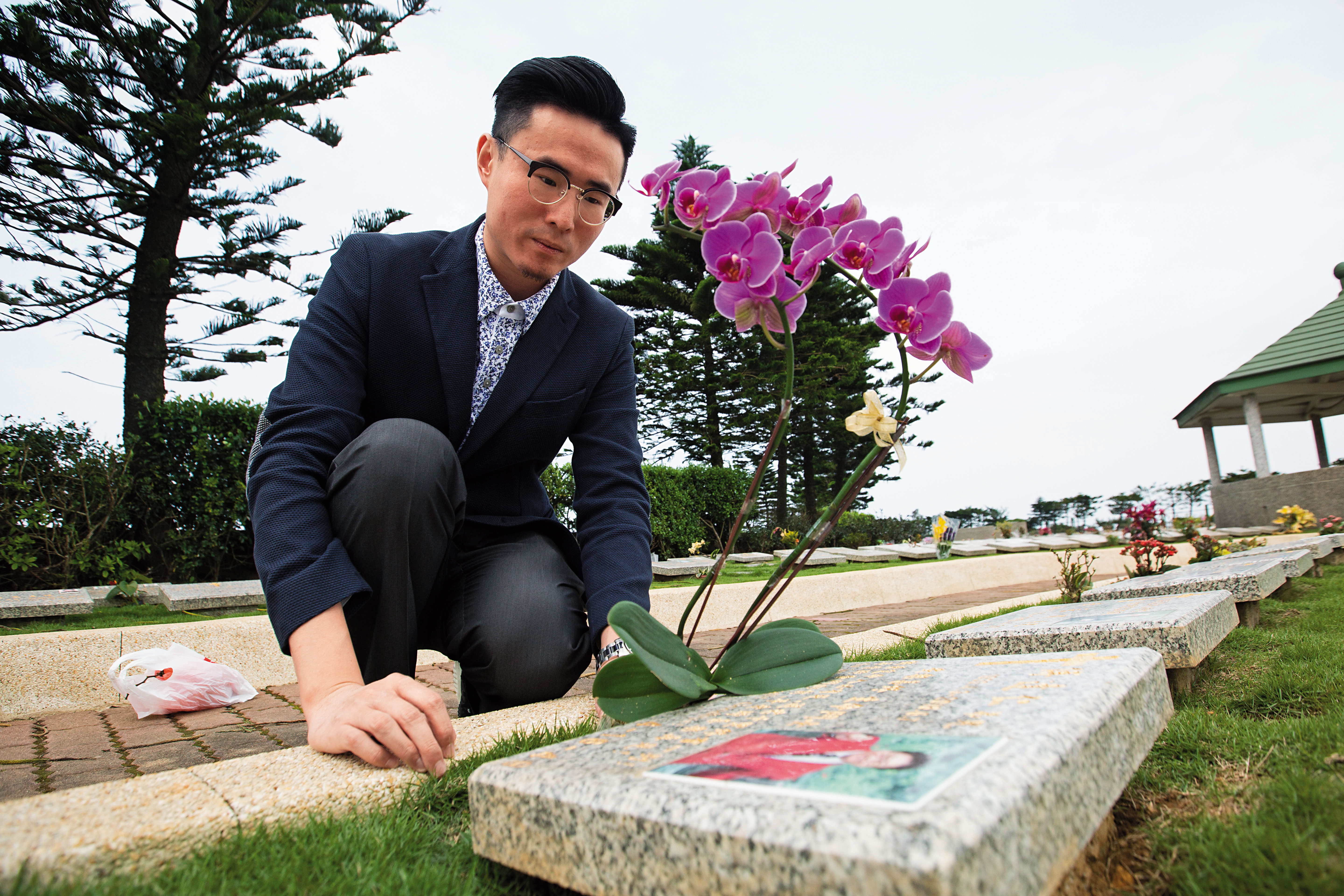 傅俊豪在墓碑前，懷想父親的一生輝煌。他將繼承父親的遺志，推動安樂死合法化。