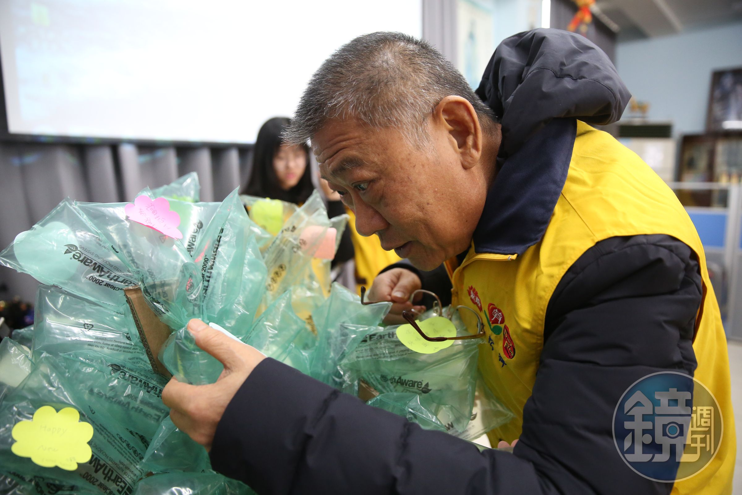 昇恆昌免稅商店董事長江松樺仔細地讀著育幼院孩童們寫下的新年願望。