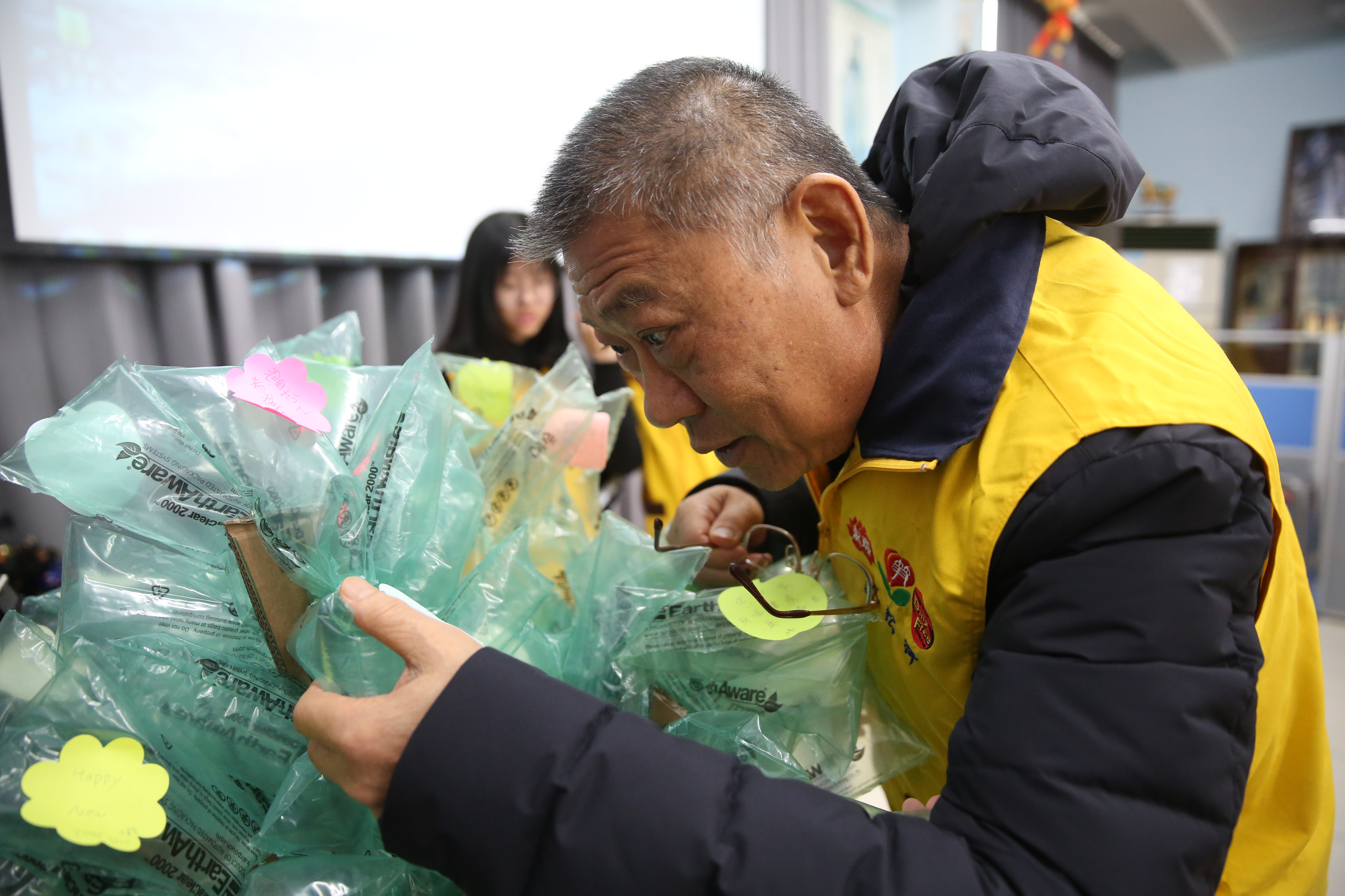 昇恆昌免稅商店董事長江松樺仔細地讀著育幼院孩童們寫下的新年願望。