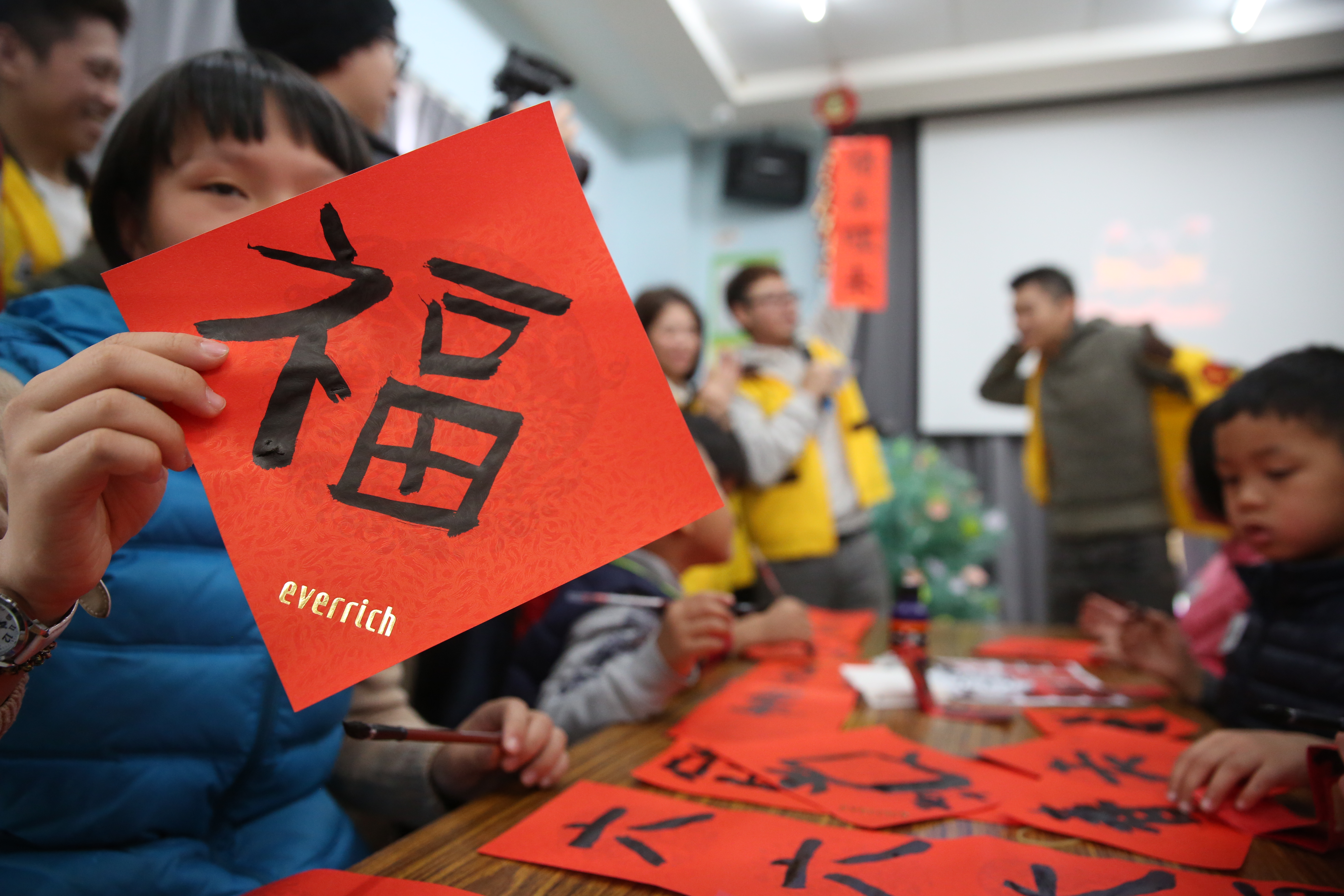 迎接農曆新年，昇恆昌志工團隊帶著育幼院孩童們揮毫寫春聯。
