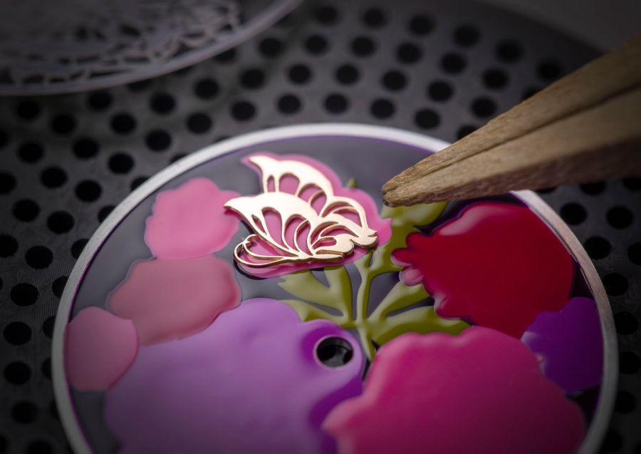 花朵上飛舞的蝴蝶，是以手工金雕所製作。