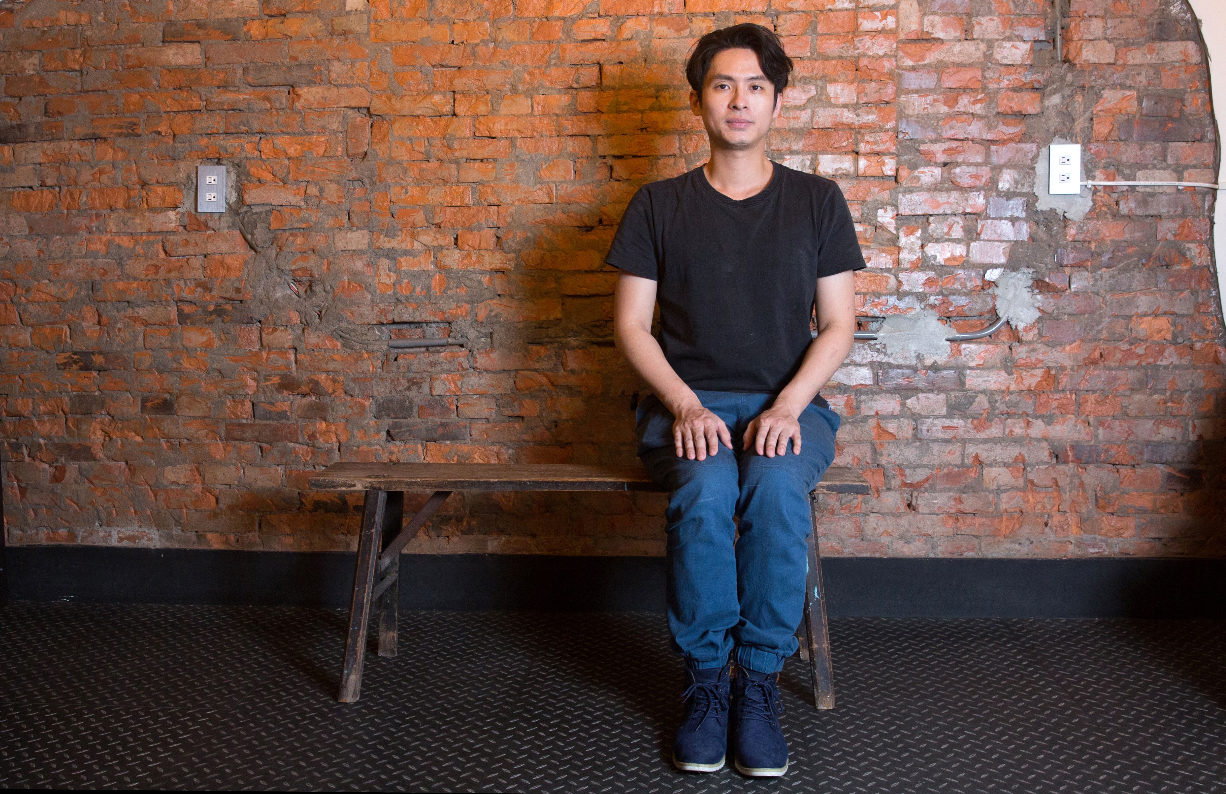 蔡岳勳在店裡重現當年舊照片裡，「好學生」的拘謹坐姿。