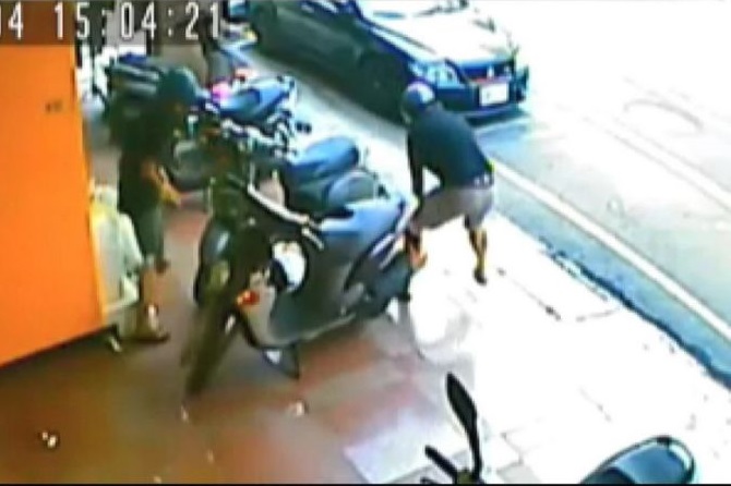 惡煞一下車便朝洪女的機車猛砸，針對性十分強烈。（翻攝畫面）