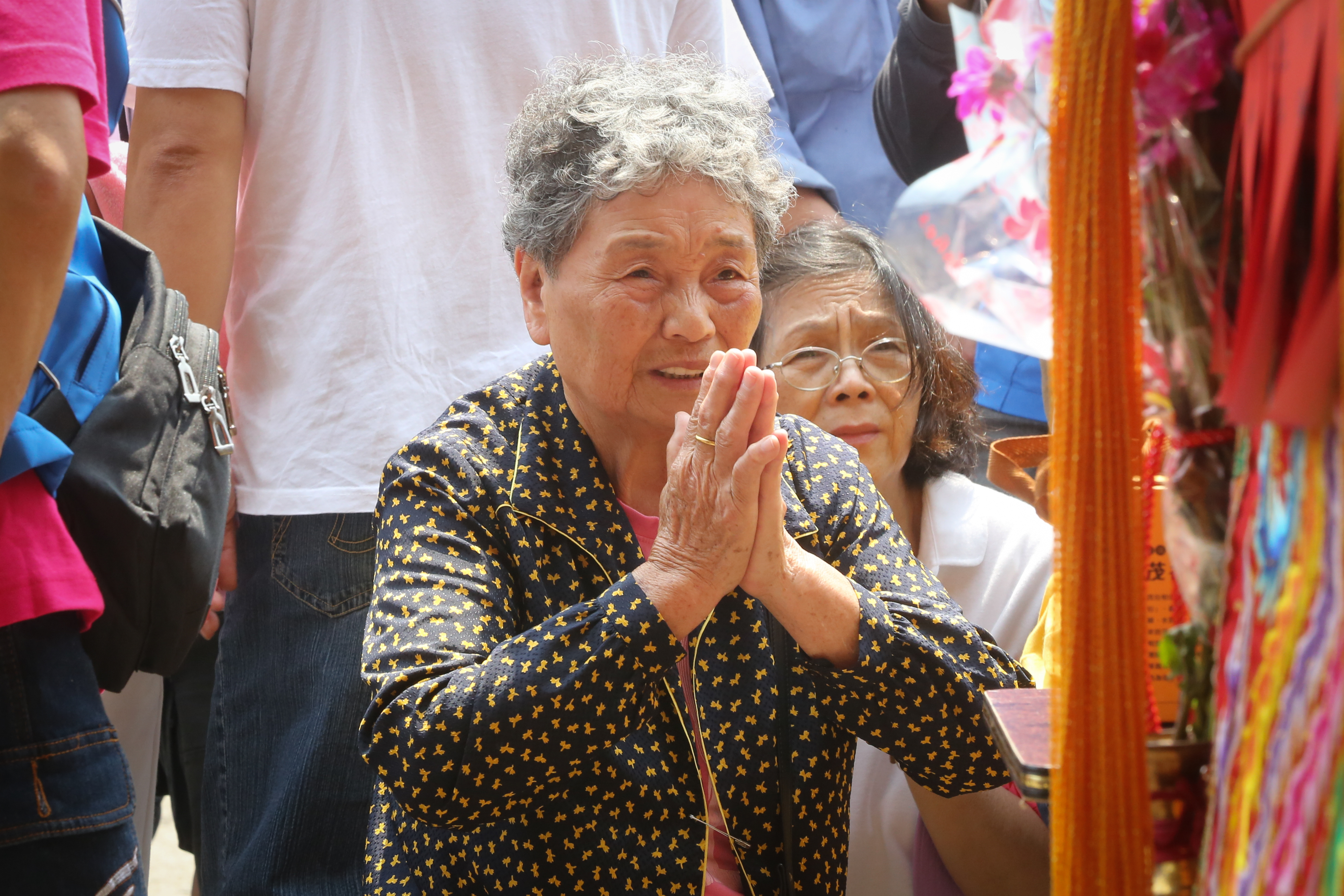 一位阿嬤虔誠地拜著媽祖。