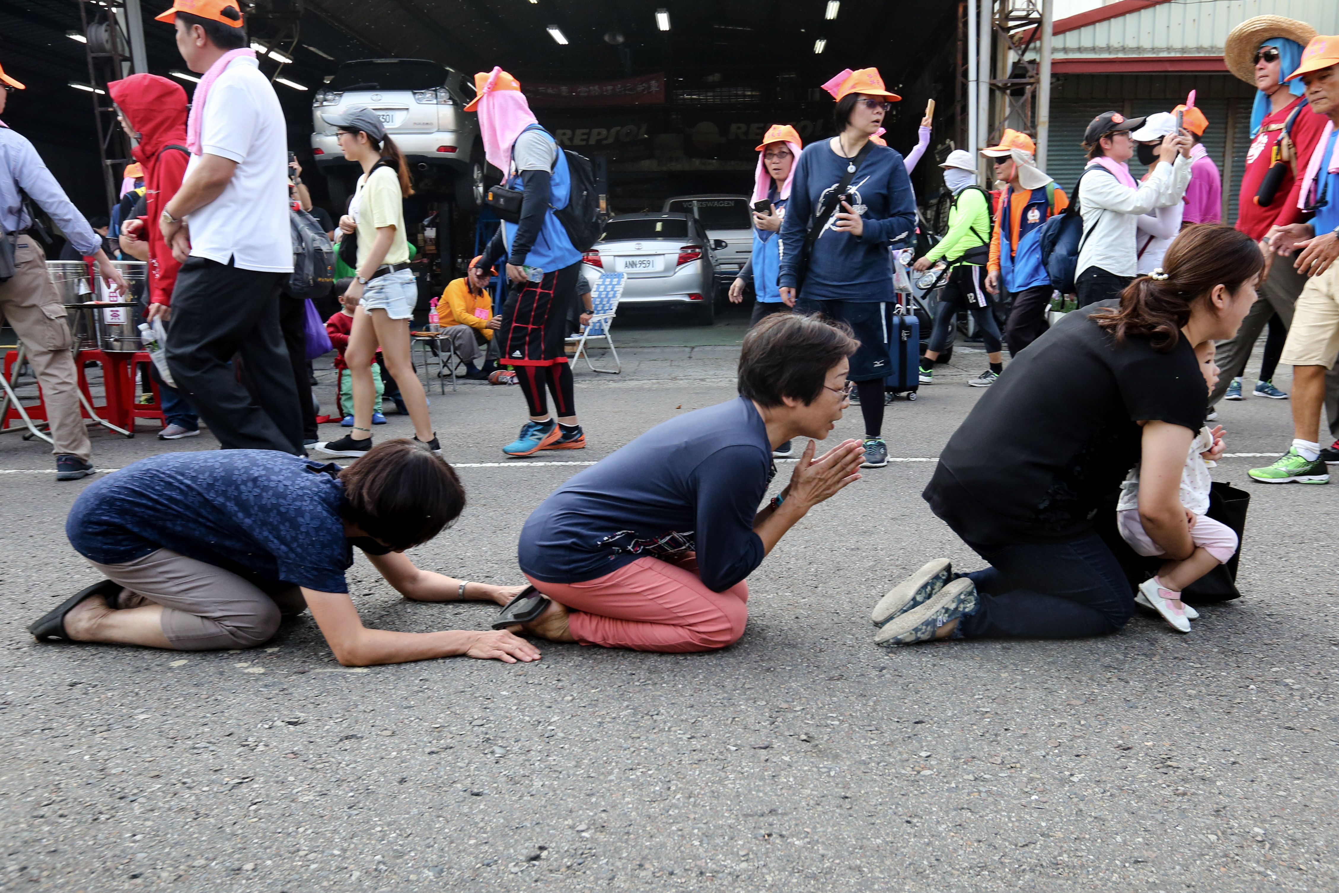 儘管柏油路炙熱發燙,民眾仍跪拜成一排,只求媽祖經過。