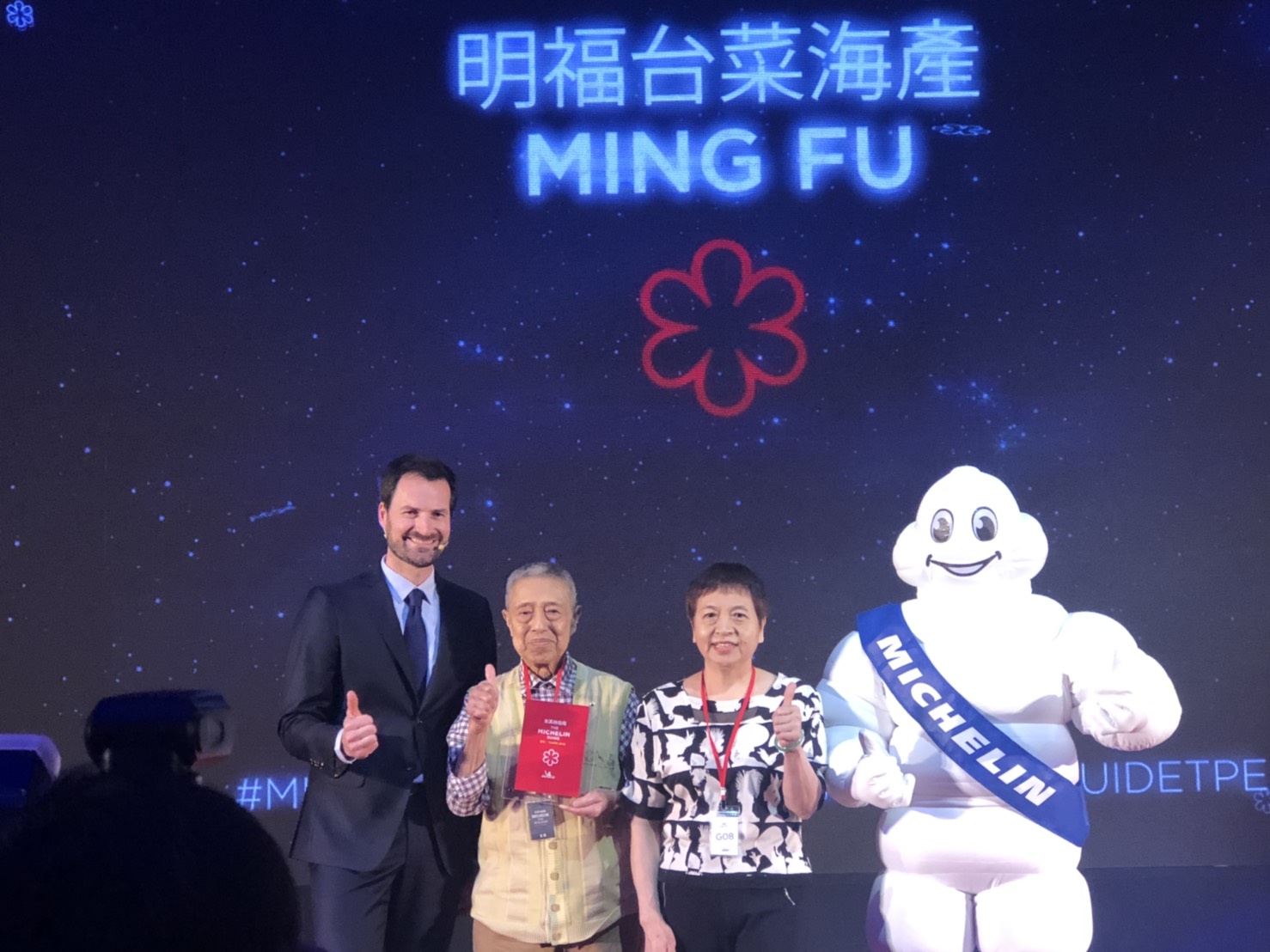 去年因為謙遜低調而沒到場領獎的一星餐廳「明福台菜海產」，今年阿明師和麗珠姐因為「歹勢嘸去領」也連袂登台領獎，成為米其林現場最溫馨畫面。