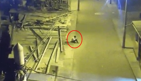 秘魯一名12歲男孩，因為家境貧困，家裡沒有電，只好在路邊靠著路燈的光線寫作業。（翻攝自推特DubaiNameShame）