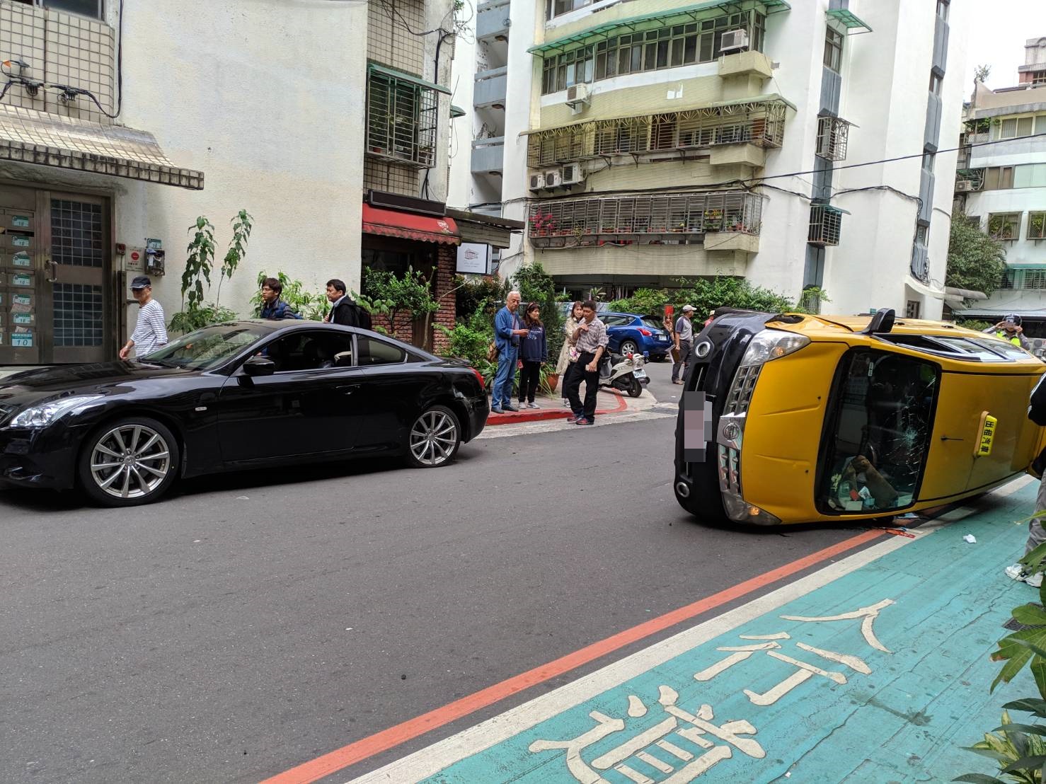 計程車撞擊路旁的百萬名車後翻覆。