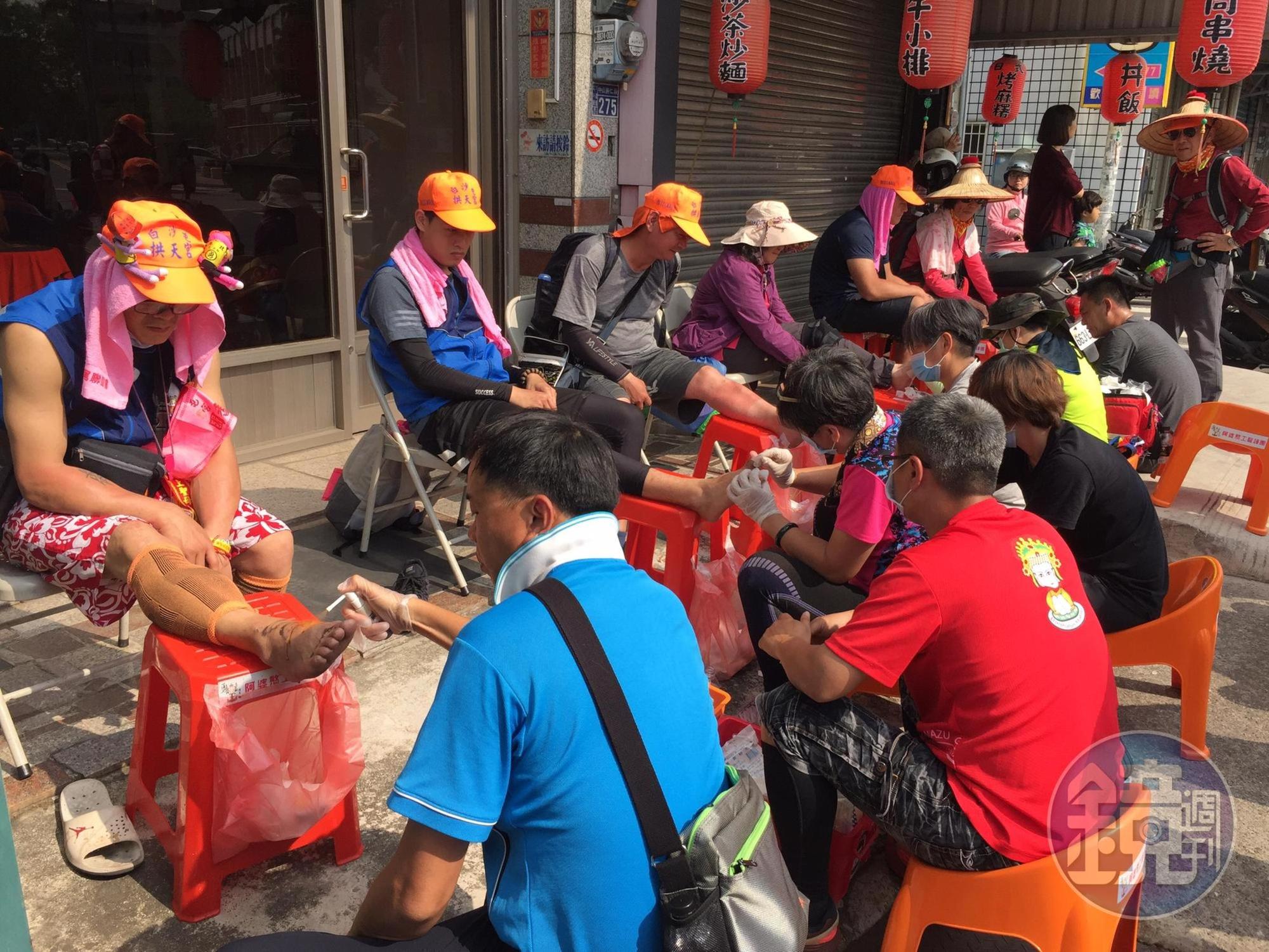 路旁不時有志工團隊，服務香客噴灑肌樂和水泡換藥。