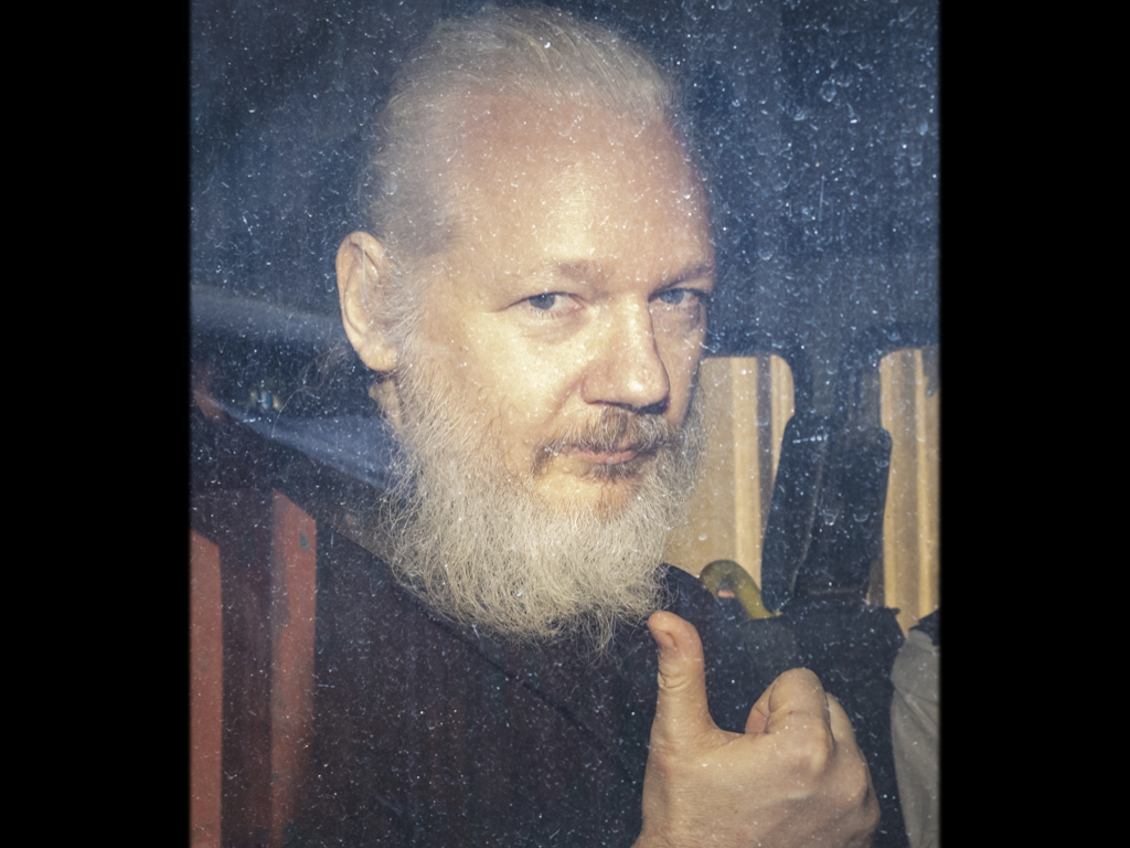 維基解密創辦人亞桑吉被倫敦警方帶至西敏法庭，途中在車內對媒體做豎起大拇指手勢。（東方IC）