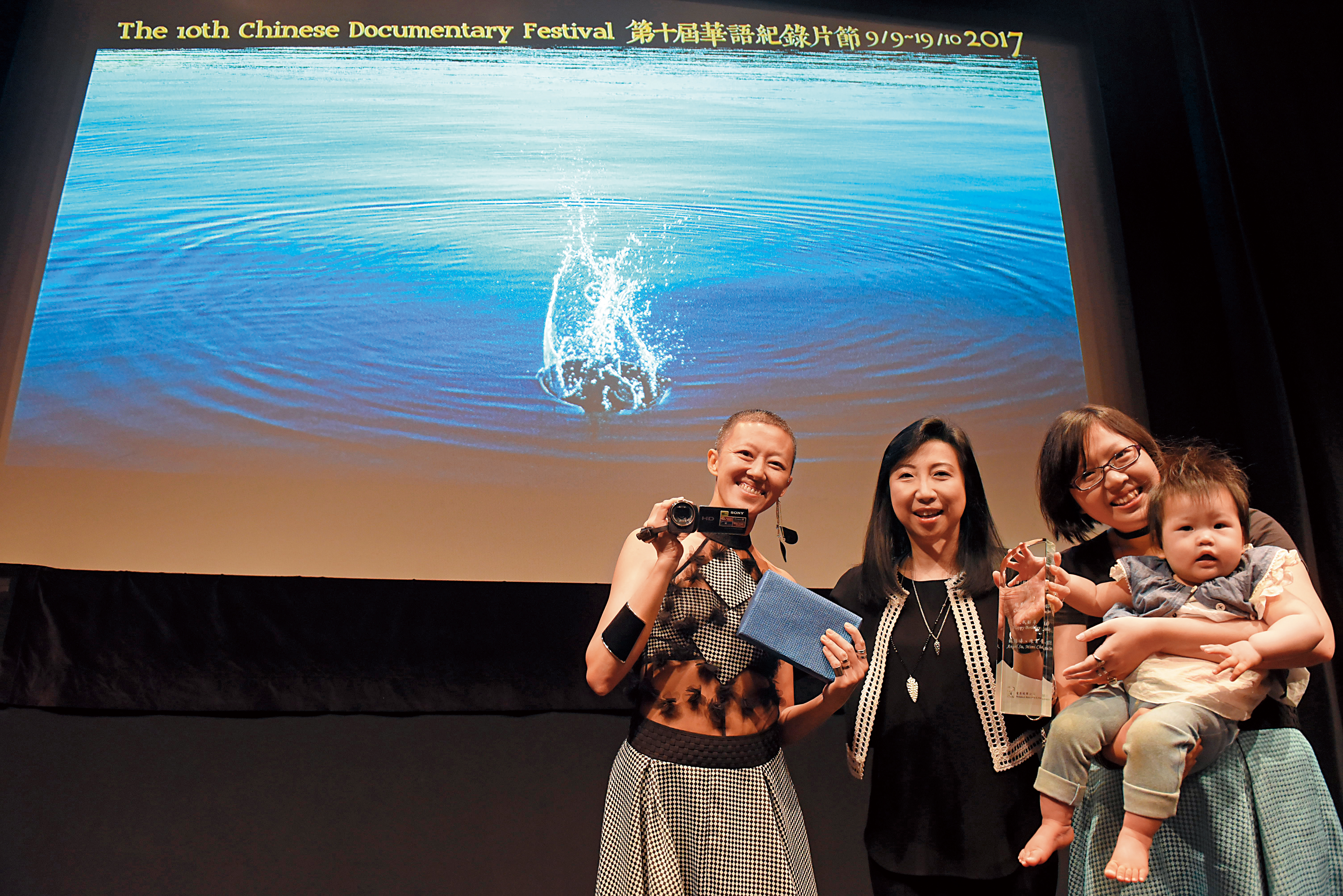 短片《祝我好孕》 獲2016年香港華語紀錄片節短片組冠軍，陳育青（左）和抱著孩子的蘇鈺婷（右）出席領獎。（陳育青、蘇鈺婷提供）