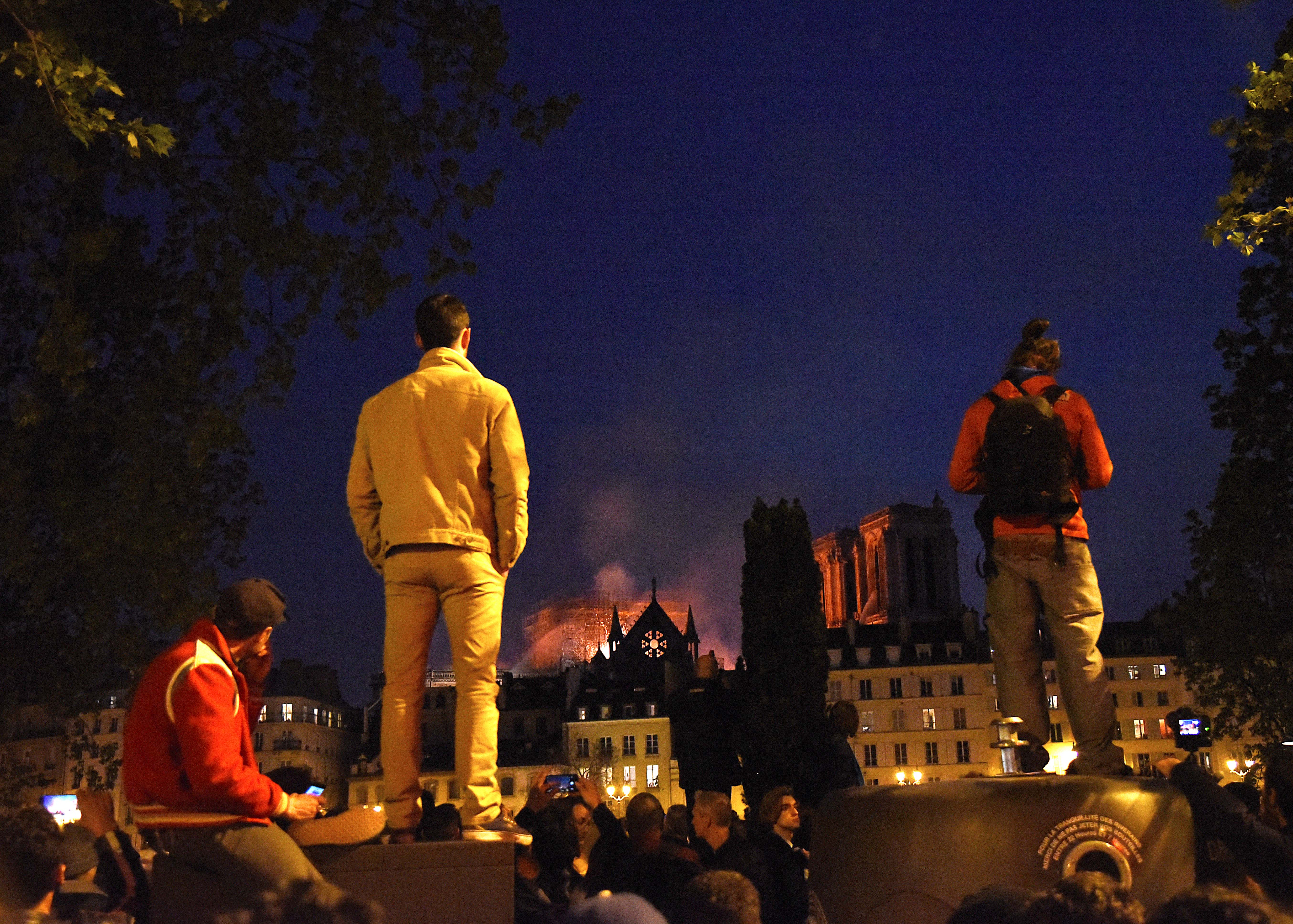 巴黎人望著火光中的聖母院,為之心碎。(東方IC)