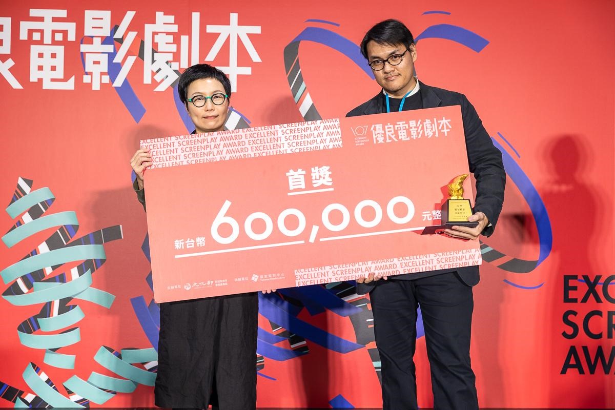 鏡文學編劇賴東澤（右）所著、結合科幻與心理驚悚類型的《紅星孤旅》，獨得107年度徵選優良電影劇本首獎60萬元獎金，由文化部政務次長丁曉菁頒獎。（文化部提供）
