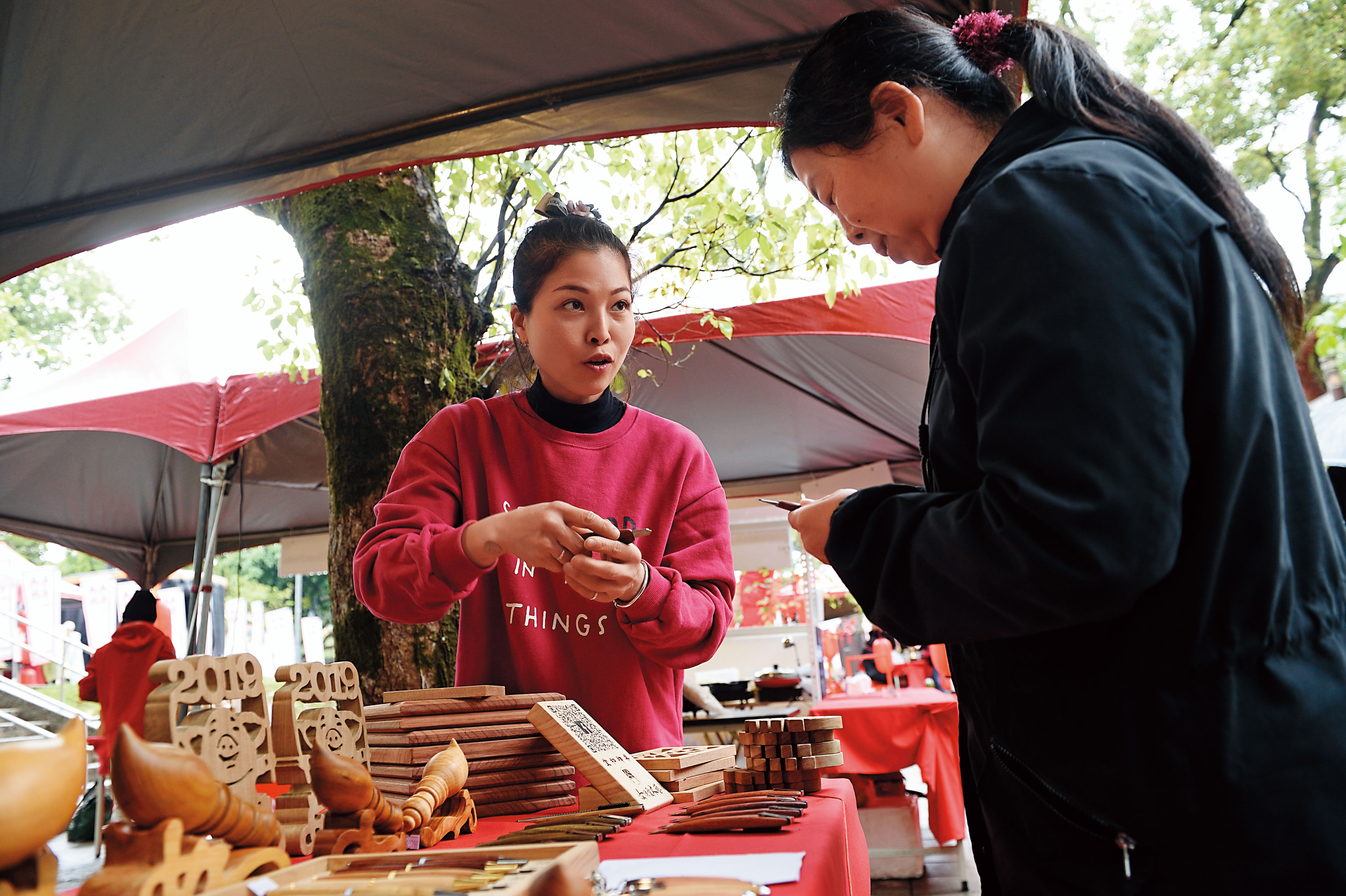 這幾年除了做神桌,黃裕凰(左)也手作文創商品,在桃園市政府辦的市集販售。