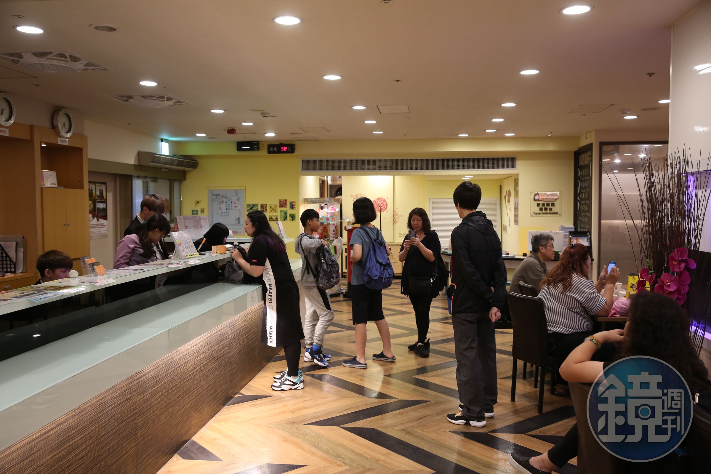 愛客發旅館櫃台前的遊客正在辦理報到（check in）手續，看起來完全沒有異狀。
