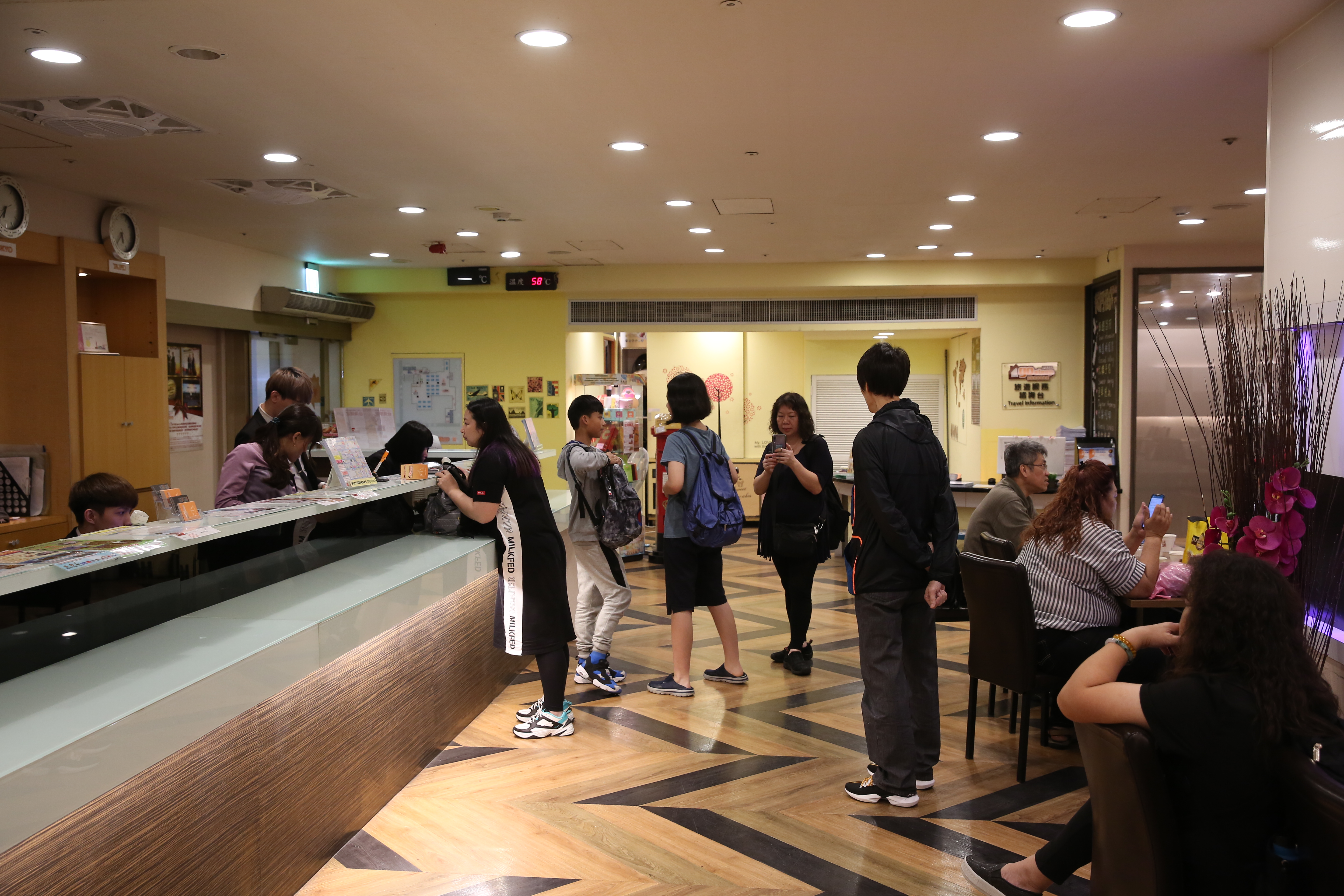 愛客發旅館櫃台前的遊客正在辦理報到（check in）手續，看起來完全沒有異狀。