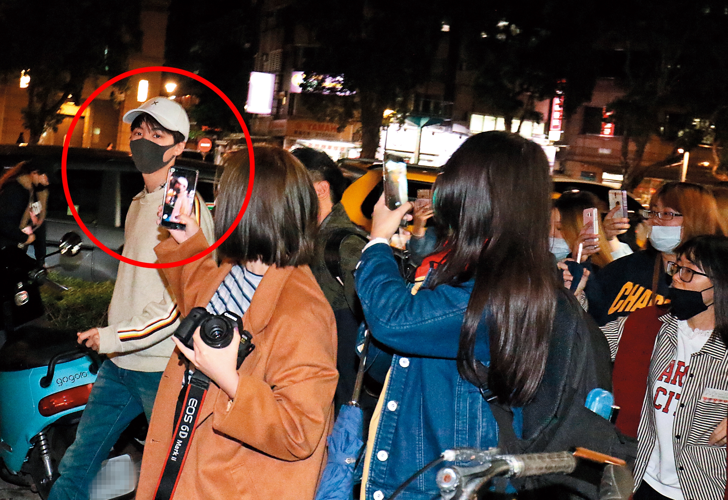 4/15 19:37 聞風而來的粉絲包圍王俊凱、紛紛拿起手機拍照，戴著帽子及口罩遮掩的王俊凱受到驚嚇、眼神顯得慌亂。