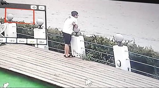 吳男被監視器拍下在三芝海邊買咖啡沉思。（翻攝畫面）