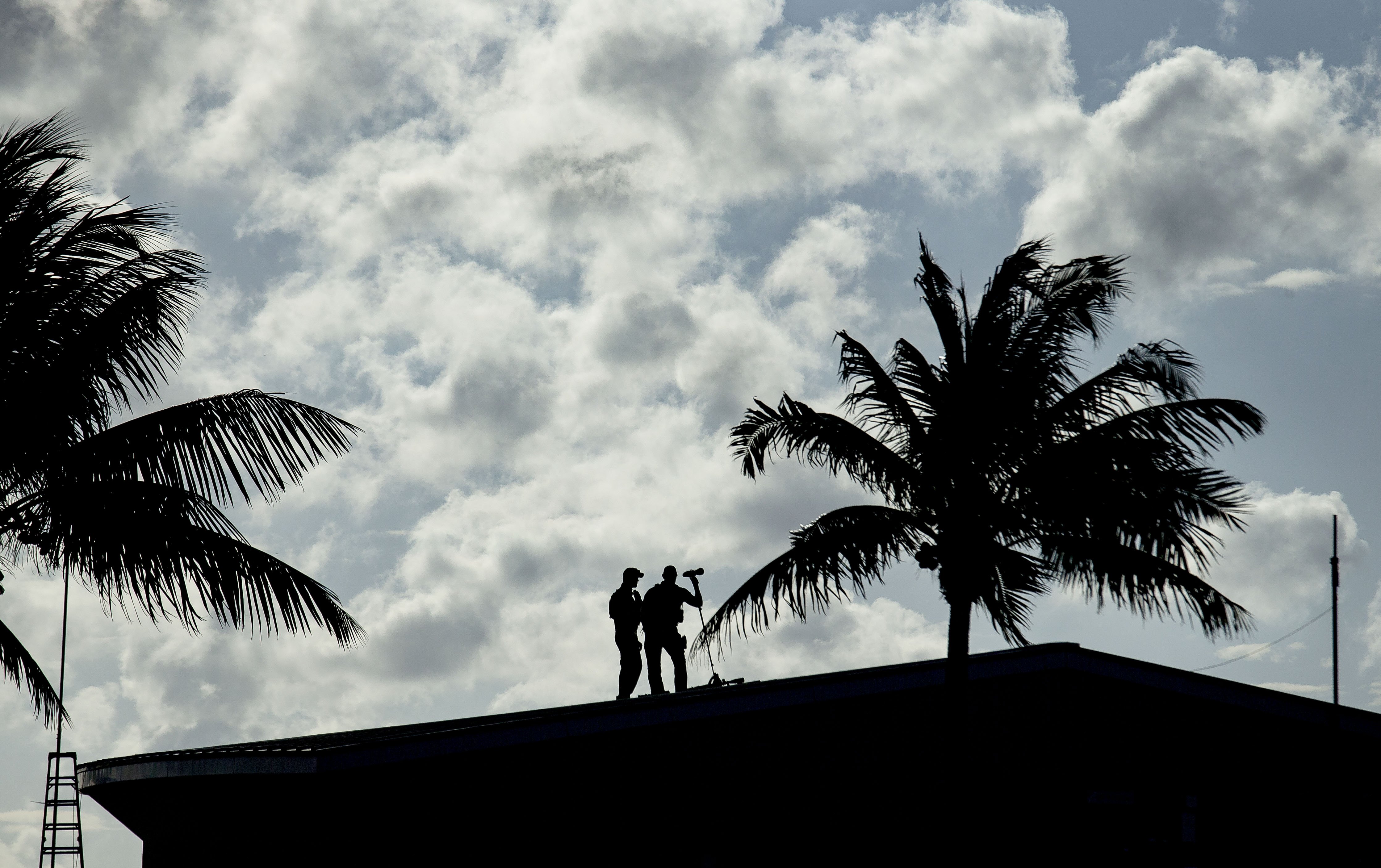美國秘勤局人員在佛州棕櫚灘一棟建築物頂上，在川普專機降落前持續觀察地面情況。（東方IC）