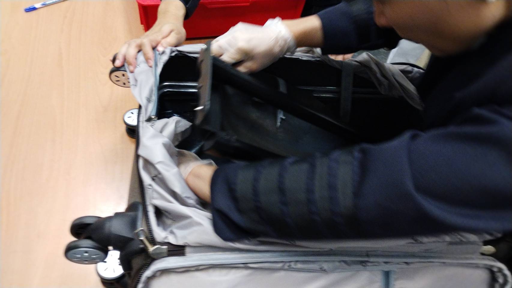 刑事局人員剪開行李箱夾層，找到6.5公斤K毒。（刑事局提供）