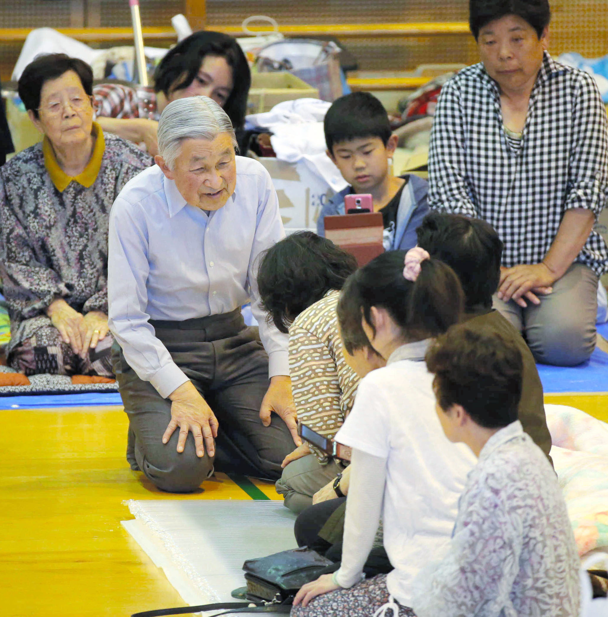 2016年熊本縣發生地震，圖為明仁天皇至阿蘇村一個充當避難所的體育場慰問災民。（東方IC）