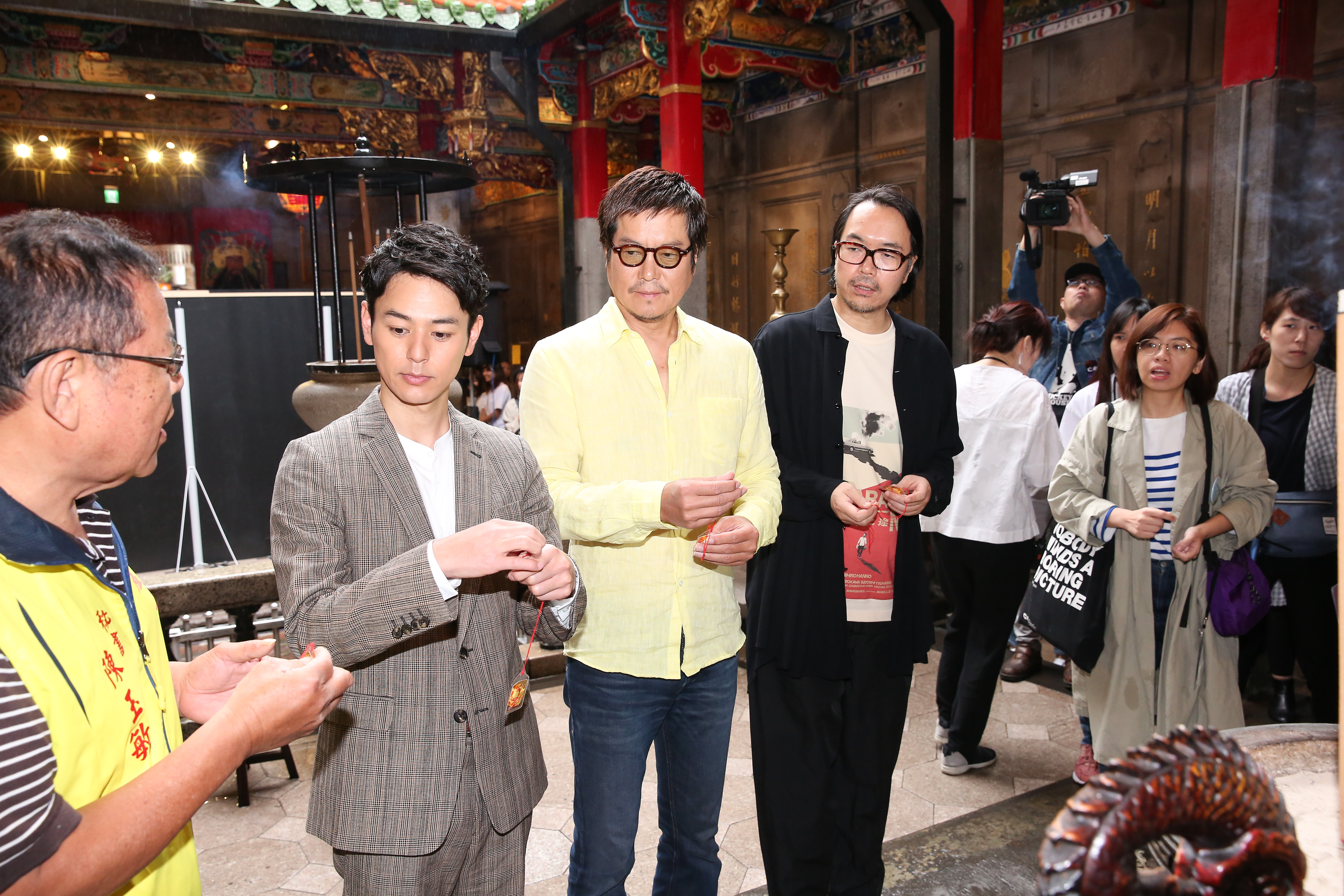 妻夫木聰（左二）、豐川悅司和導演半野喜弘拿著平安符，繞香爐求保祐。