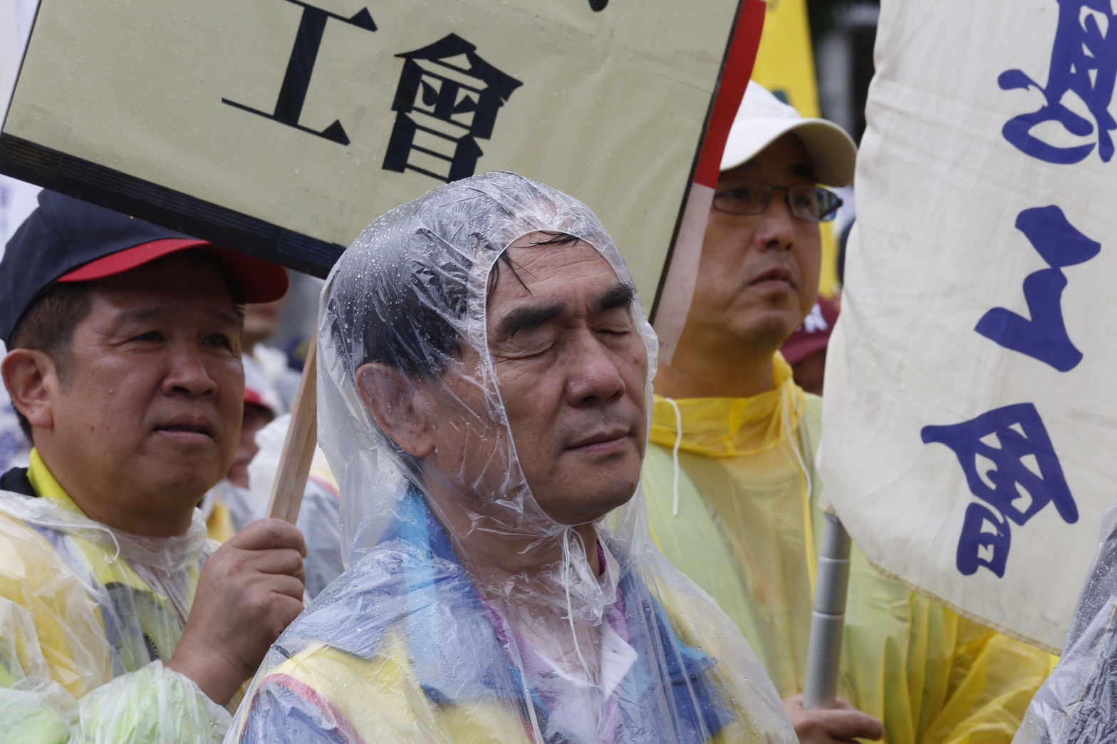 五一勞工大遊行雨中登場，參與遊行的勞工穿著雨衣拿著標語，高喊訴求。