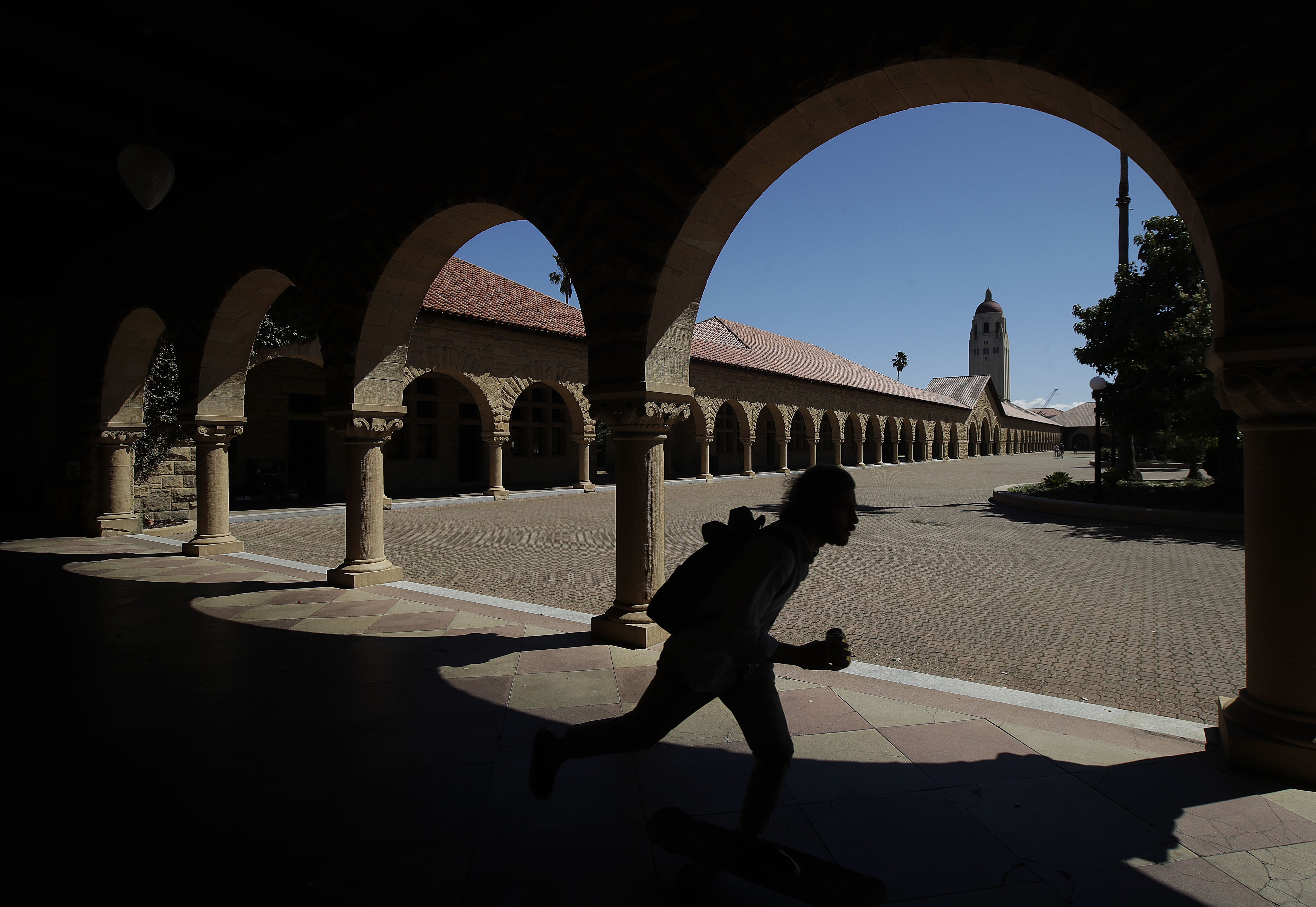 美國史丹佛大學，一名學生溜著滑板經過校園。（東方IC）