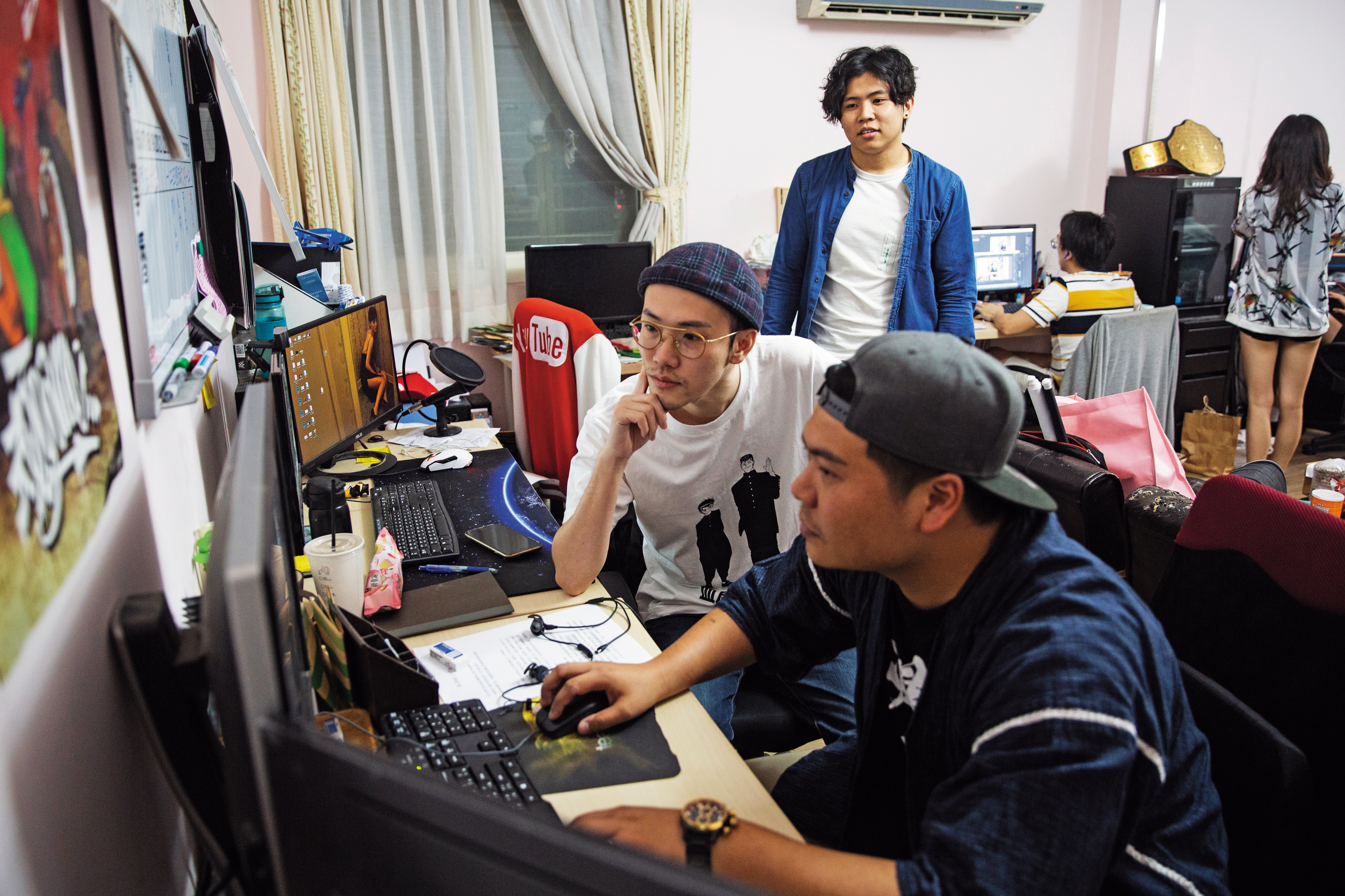 華森(中)和夥伴鐵牛(前)在辦公室剪片,他們2人也是「頑game」的常駐演員。