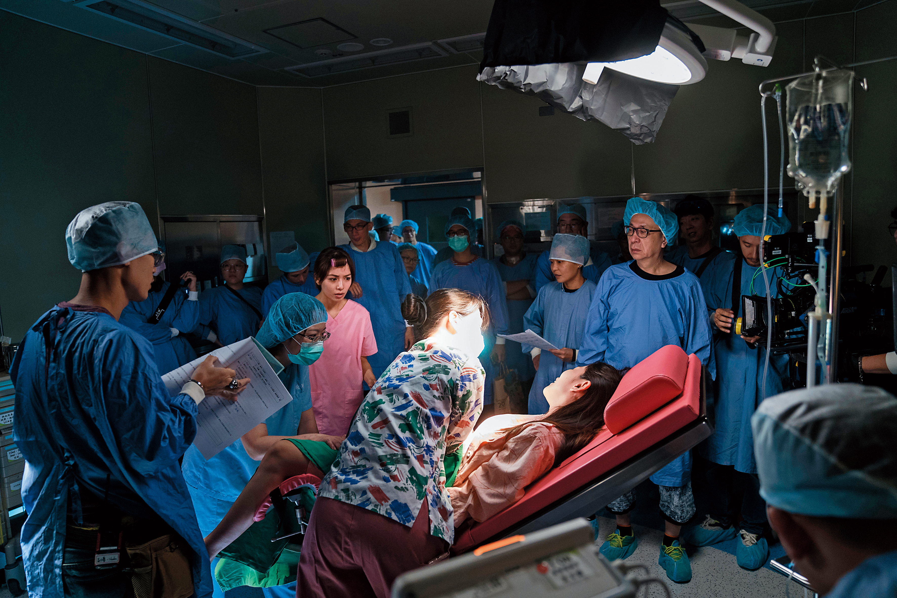 《生死接線員》獲彰化基督教醫院協助支援手術室場景，提升戲劇寫實度。攝影指導車亮逸（右一）及燈光指導蔡禮雄（右二）在場調度。（公視提供）