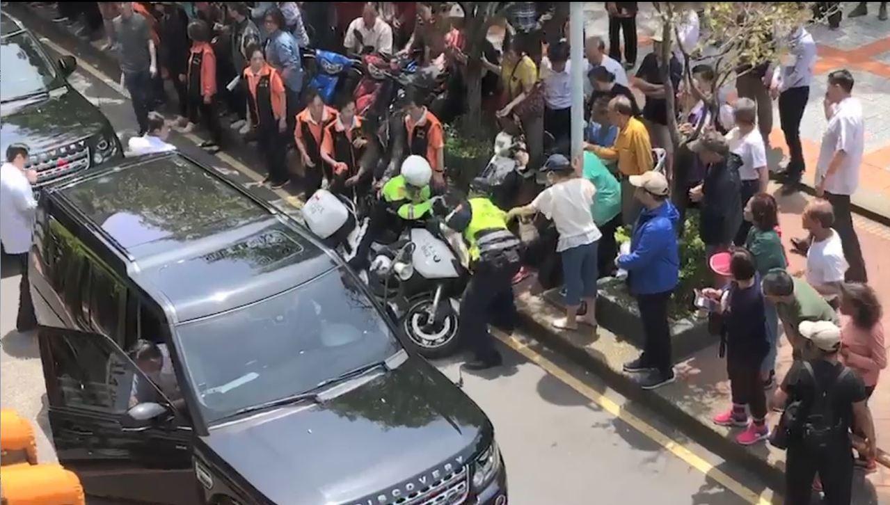 一名總統隨扈因開車門未注意一旁車輛，導致員警、民眾被碰倒。（翻攝畫面）