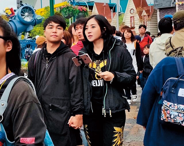 張峰奇（左）和李亮瑾（右）穿同款情侶裝，十指緊扣蜜遊日本環球影城。（讀者提供）