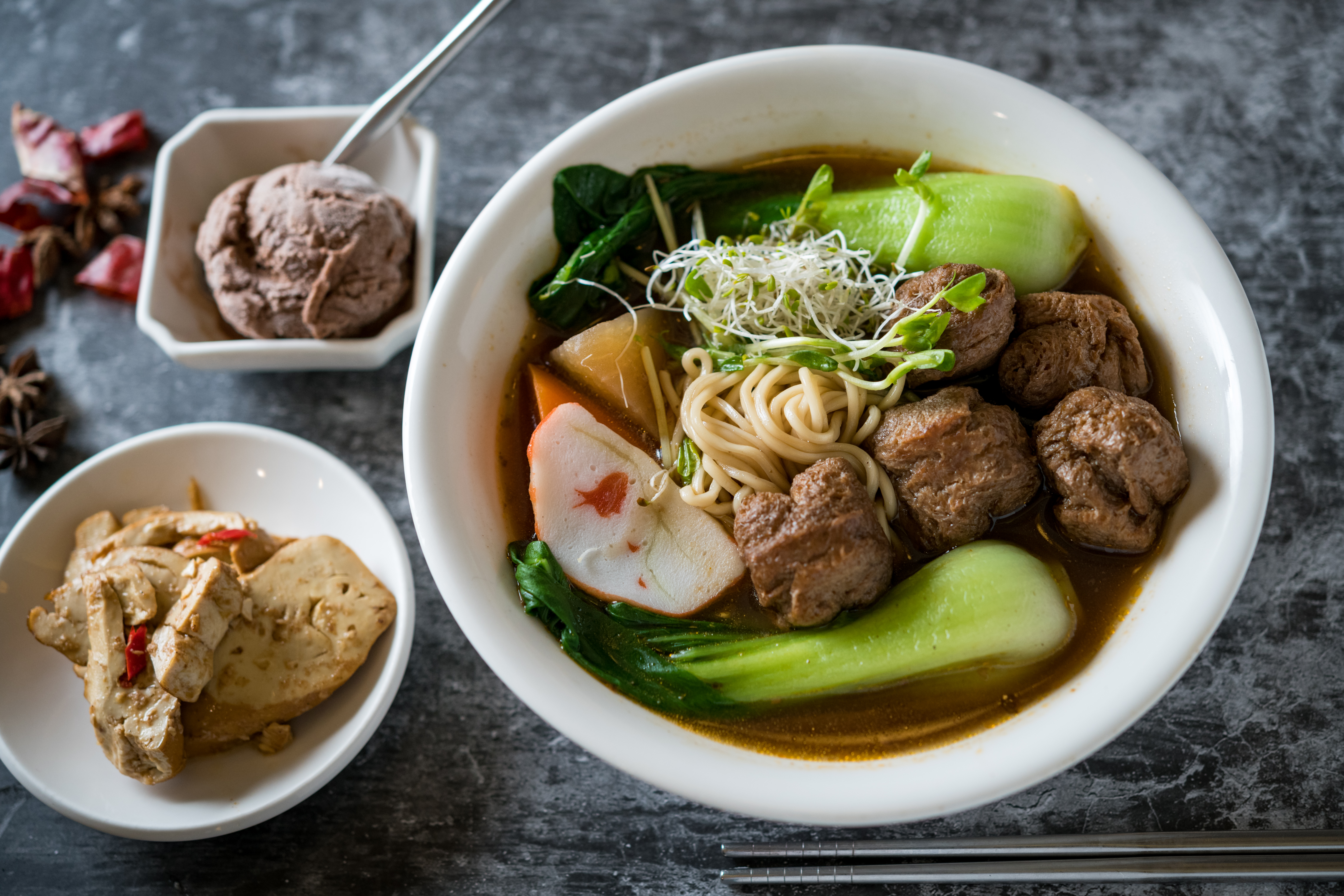 「麻辣牛腩麵」的湯頭甘甜微辣，用大豆蛋白做成的牛腩，口感類似麵筋，特別吸湯，麵條滑Ｑ。（85元／份，限平日中午供應）