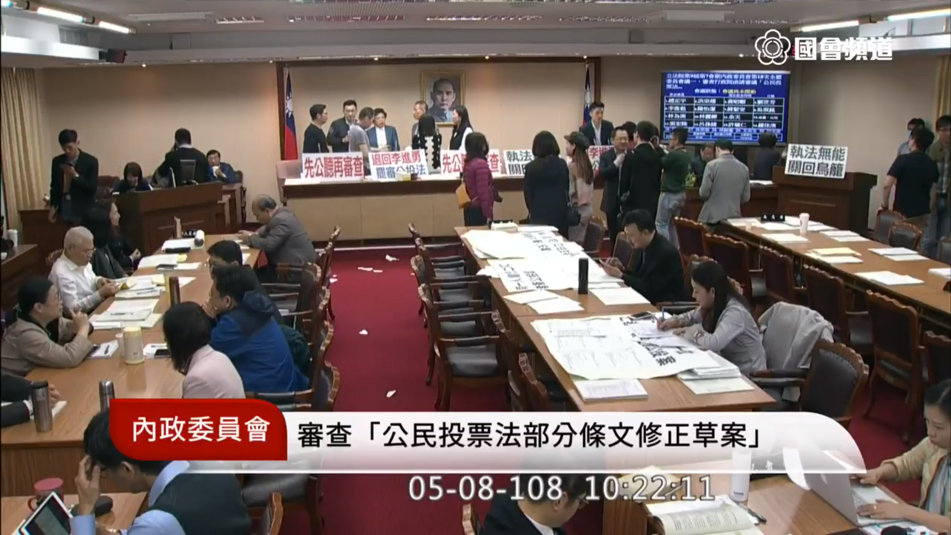 國民黨立委杯葛內政委員會審查《公投法》修法，不過藍委蔣萬安（舞台上右方螢幕旁）與柯志恩、李彥秀的聊天內容卻意外透過轉播公開播送。（翻攝YouTube國會頻道）