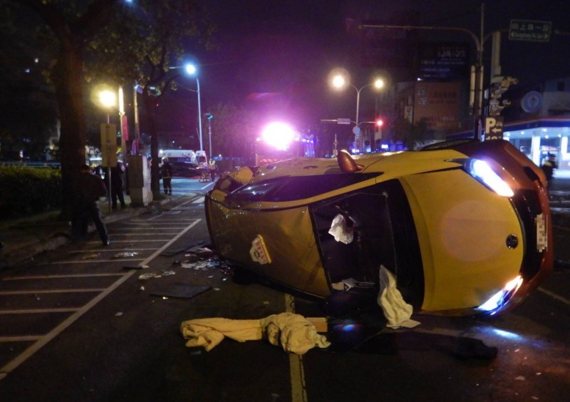 計程車側翻路中，零件散落一地。（警方提供）