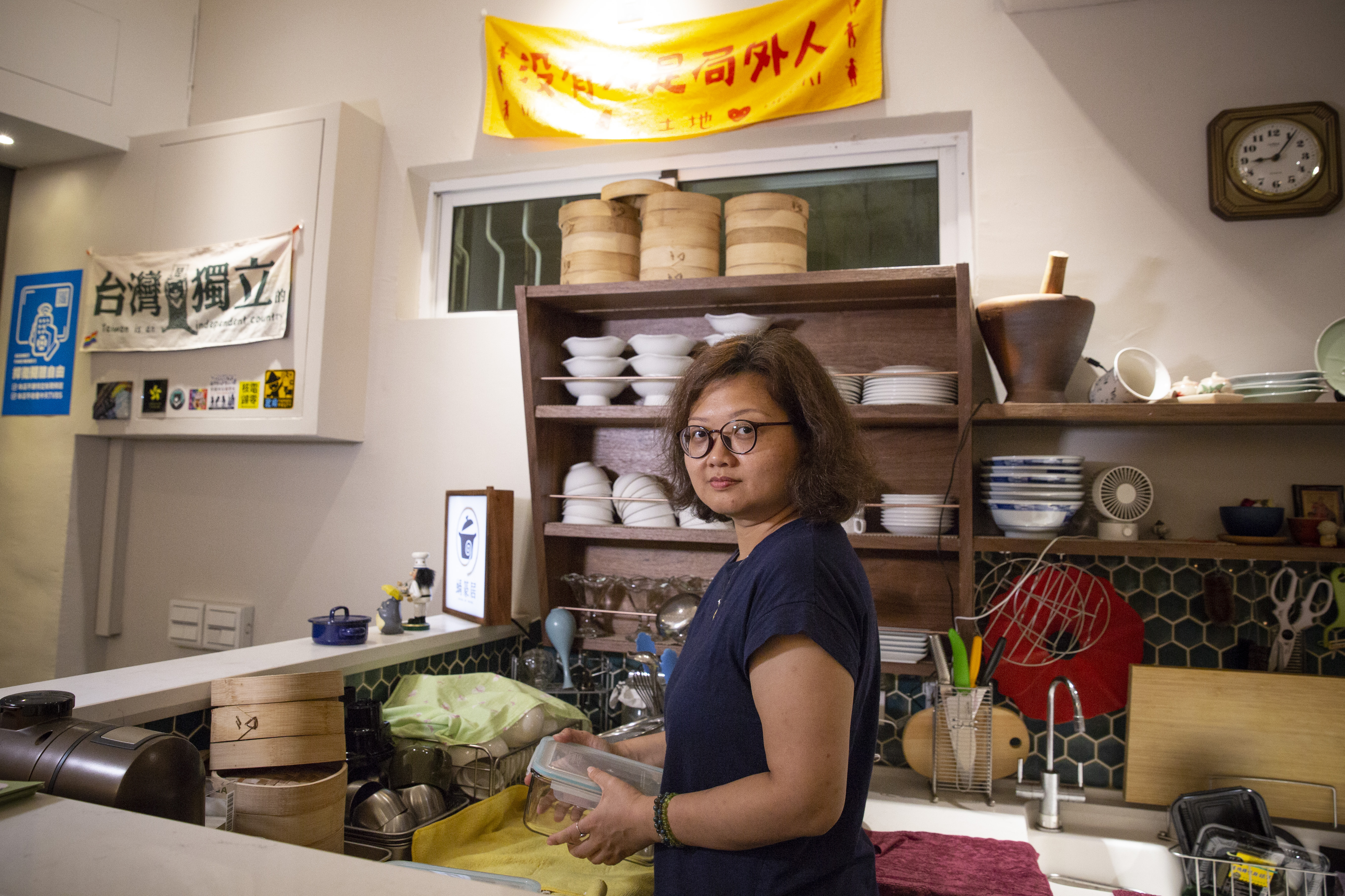 鍾慧沁胸前有個黃絲帶的墜子，象徵支持雨傘革命，也在餐廳裡掛滿各式社運標語，她不怕被貼標籤，怕的是明年台灣總統大選後，台灣會否變成另一個香港。