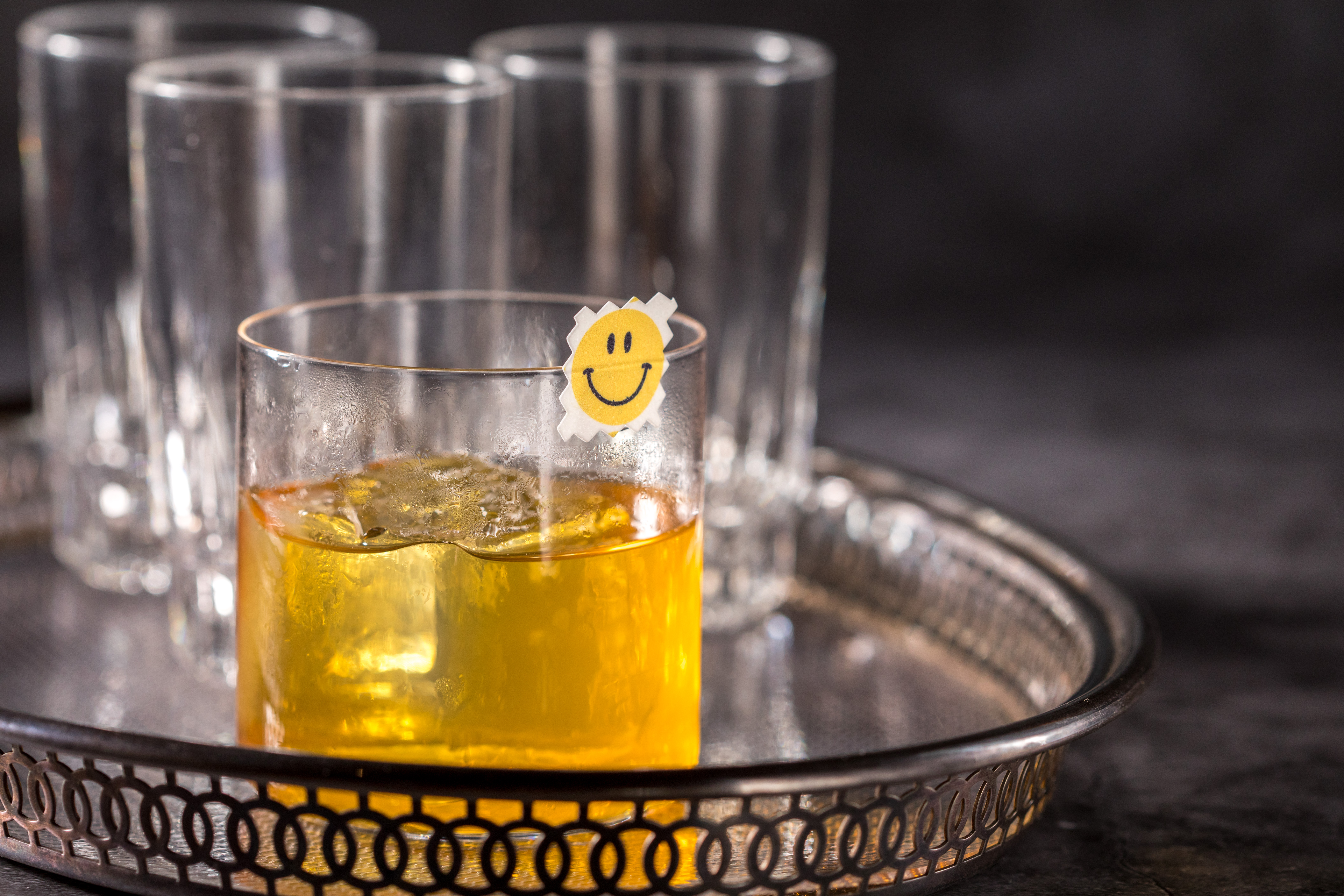 「L.S.D」酒色似威士忌,杯口的笑臉貼紙可食用,澄清後的椰棗加上橙花,一飲結構鮮明。(450元/杯)