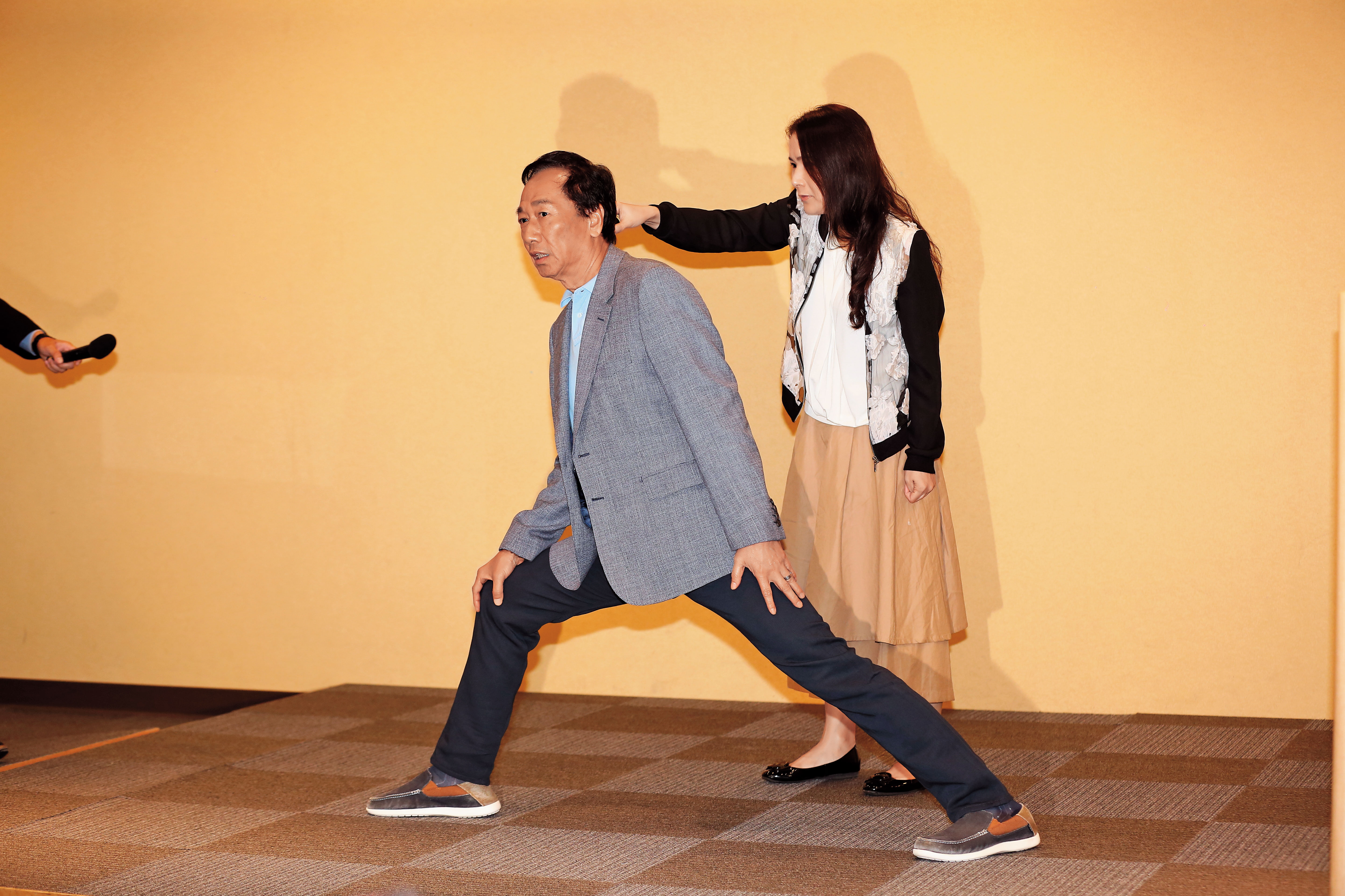 本月6日郭台銘（左）親自示範「雙腿論」，率領小編團隊的永齡基金會執行長劉宥彤（右）在旁替郭拿麥克風。