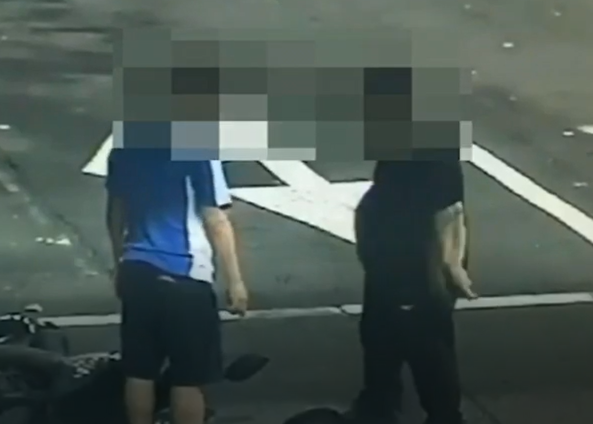 2人在街上爆發全武行，機車還翻倒一旁。（警方提供）