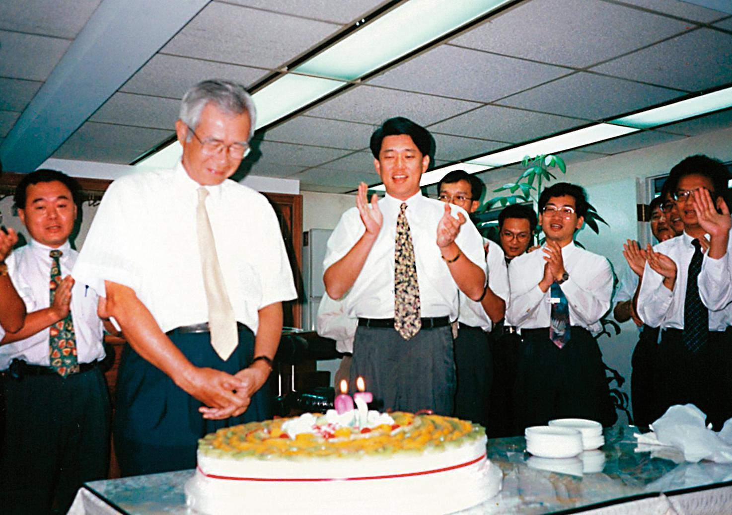 崇越創辦人張永然(前左)70歲大壽時,郭智輝(中)率同仁為他唱生日快樂歌,2人情同父子。(崇越提供)