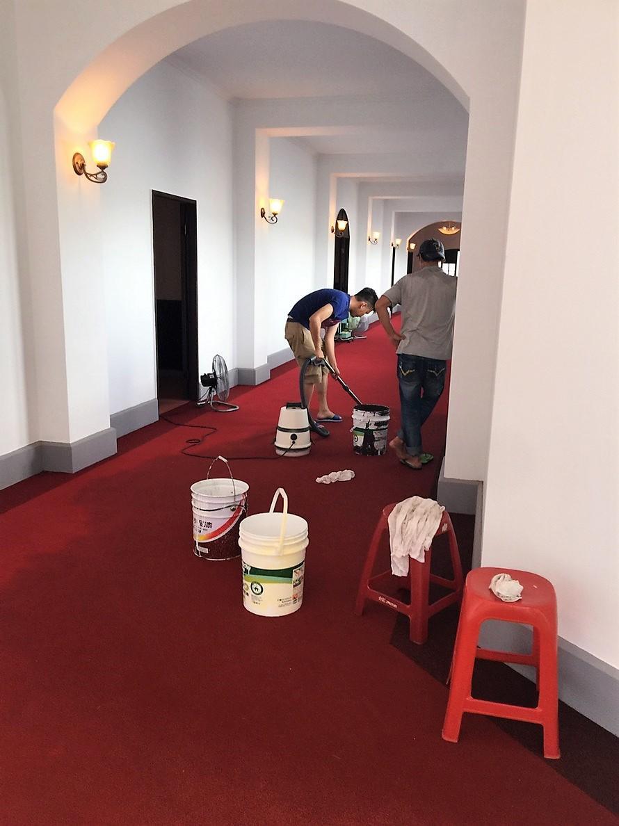 《國際橋牌社》劇組工作人員拿起吸塵器吸水搶救地毯。(馬克吐溫國際影像公司提供)