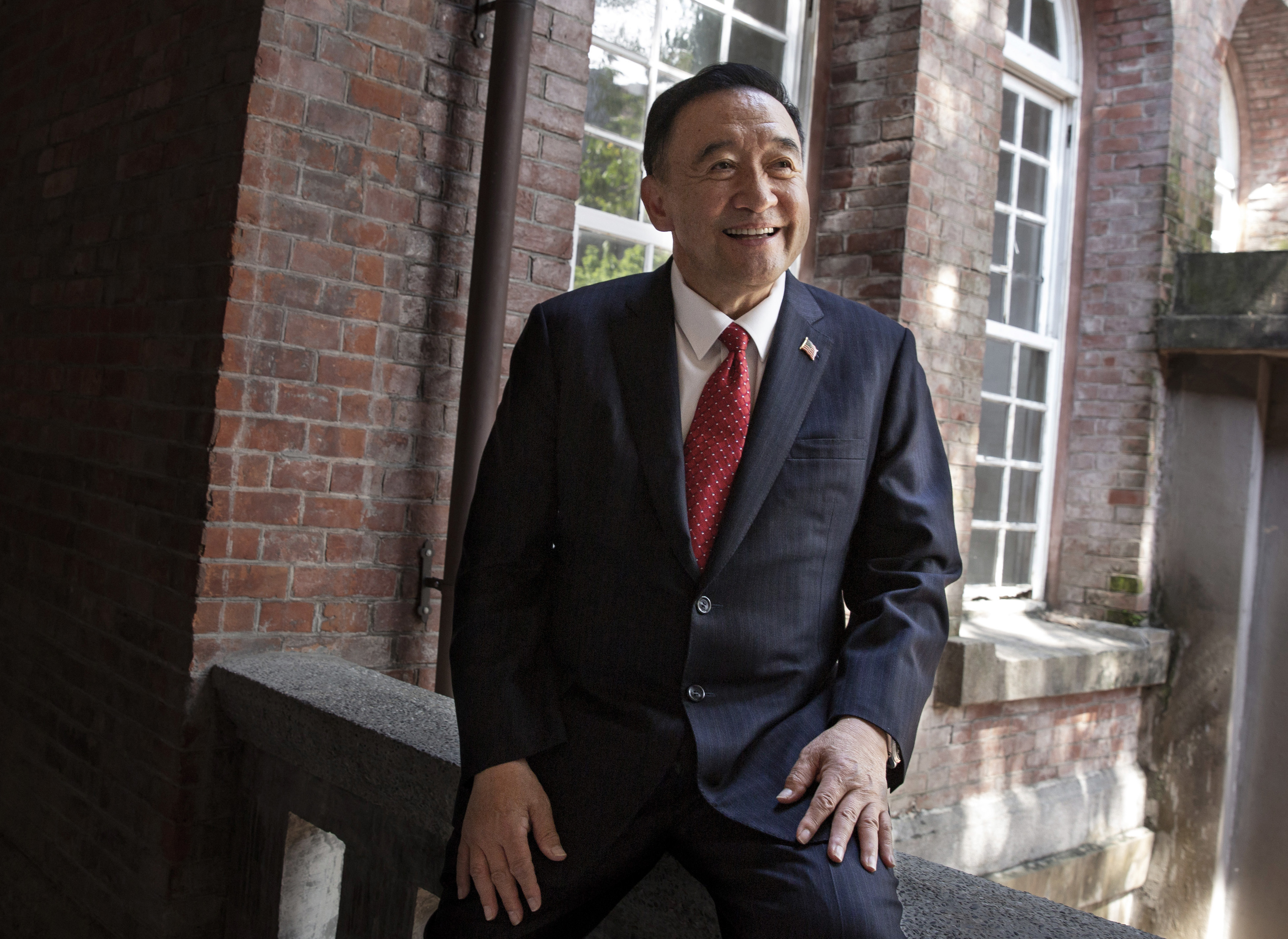 林元清的西裝外套領口，常別著美國國旗徽章。（林元清提供）