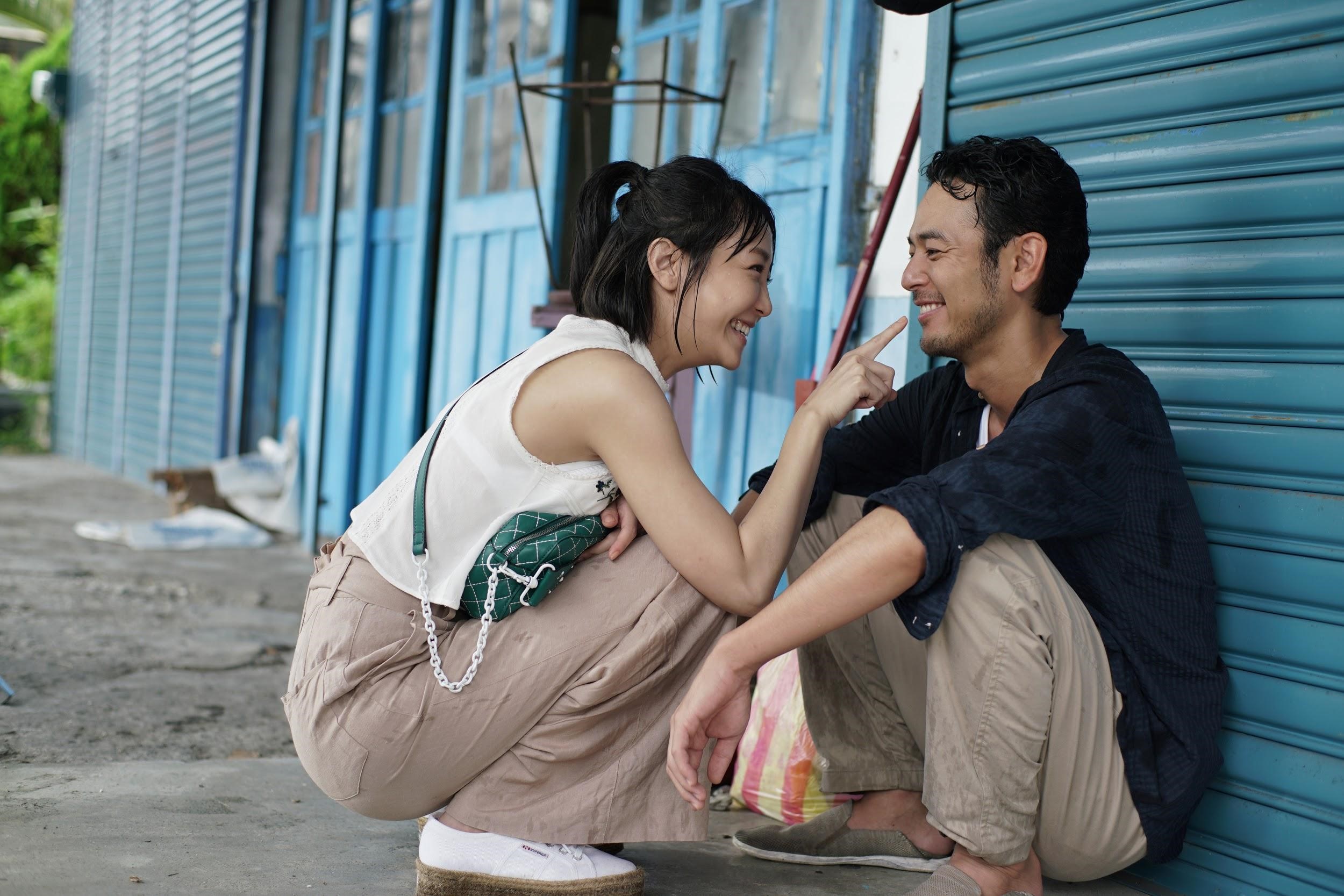 謝欣穎（左）和妻夫木聰在《亡命之途》片中有一場在屋簷下躲雨的戲，是用長鏡頭拍攝，導演半野喜弘自認有一點接近侯孝賢的風格。（威視電影提供）