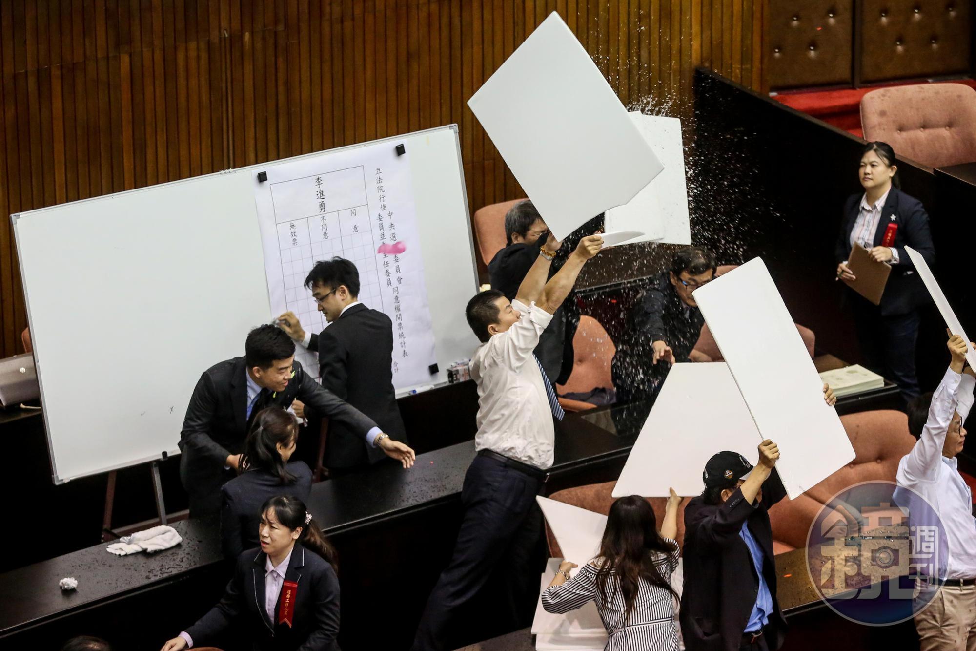 議事人員也拿起看板阻擋水球干擾開票。