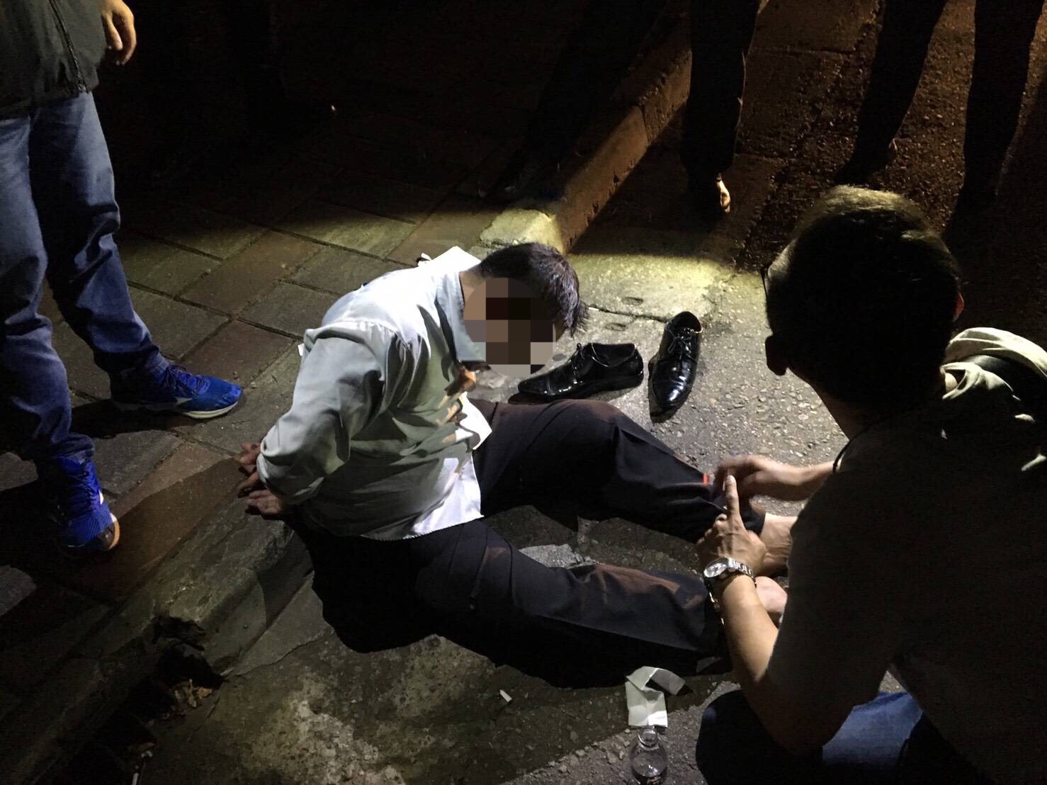 林嫌穿著皮鞋行搶，被逮後頹坐路旁。（警方提供）